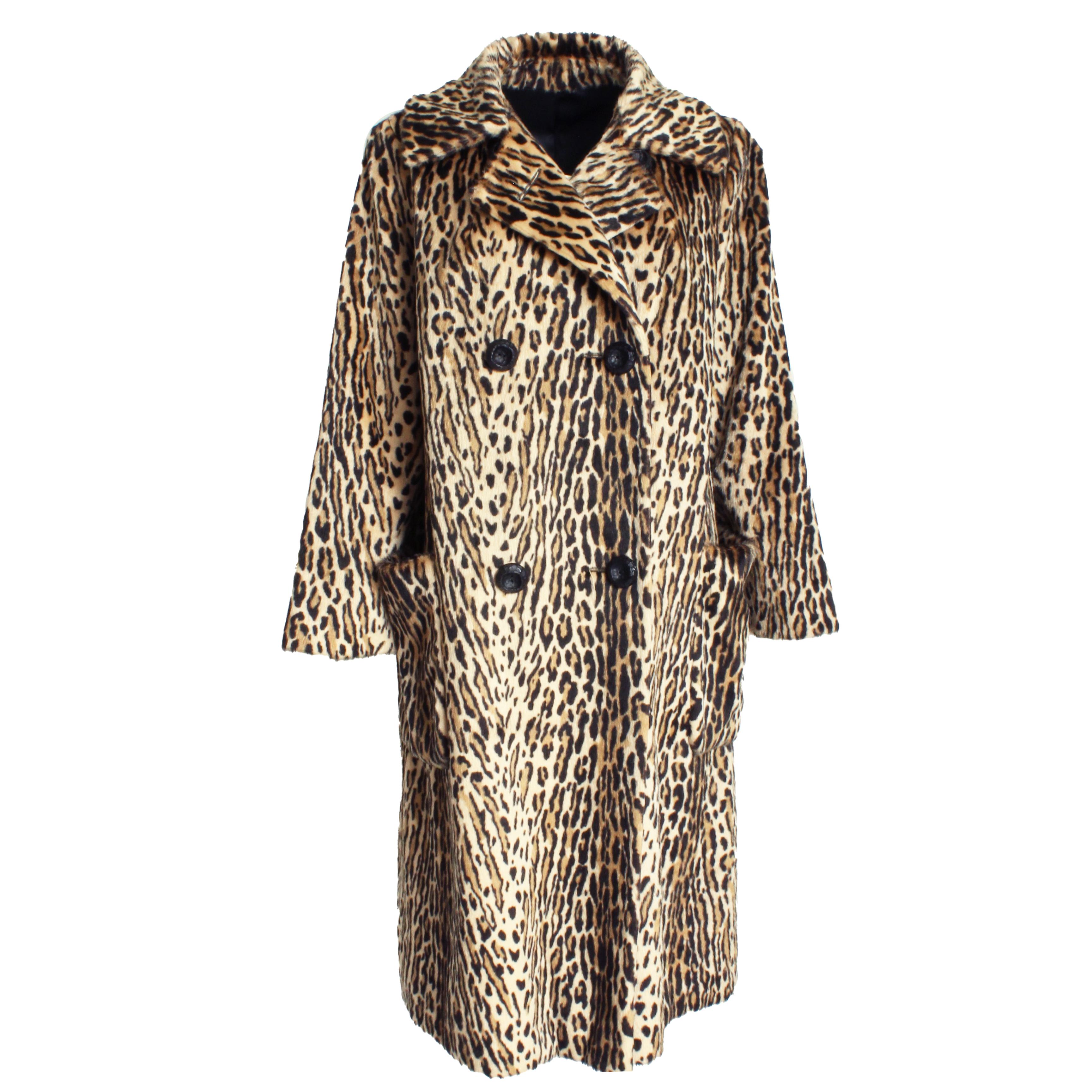 Preowned and vintage faux leopard fur coat, likely made in the 70s. Made from a faux leopard print pony fur, it's double-breasted with a wide lapel and fastens with decorative black buttons. Large pouch pockets at each hip and a pull-through partial