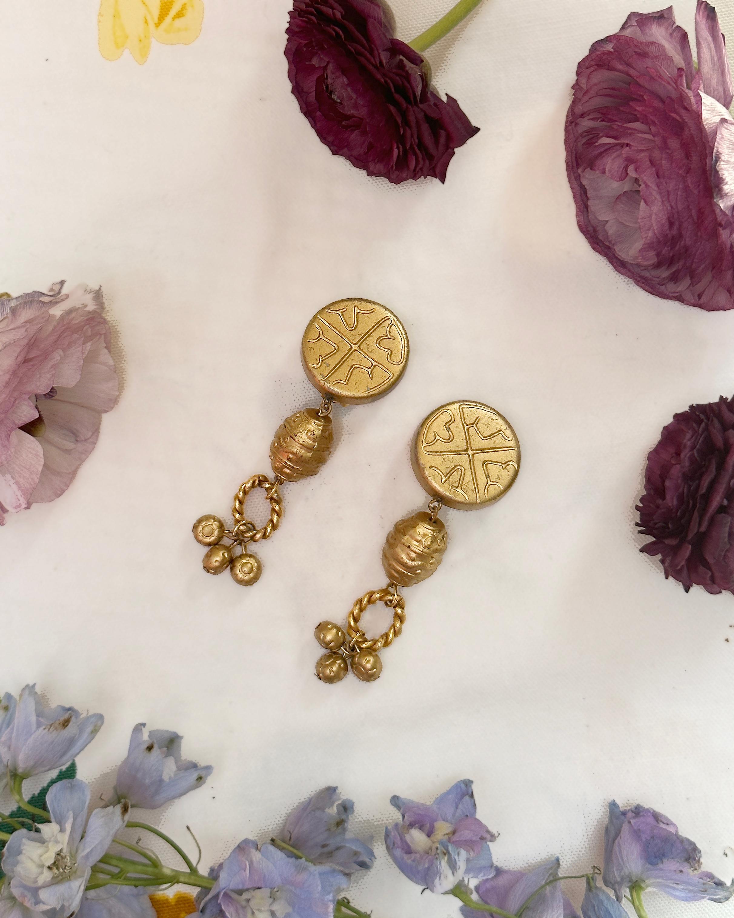 These vintage gold statement earrings were made by Les Bernard in the 1980s. The etching and sculptural details are a marriage of Etruscan and Pre-Columbian jewelry styles. I love that each individual drop and charm connects on its own ring,