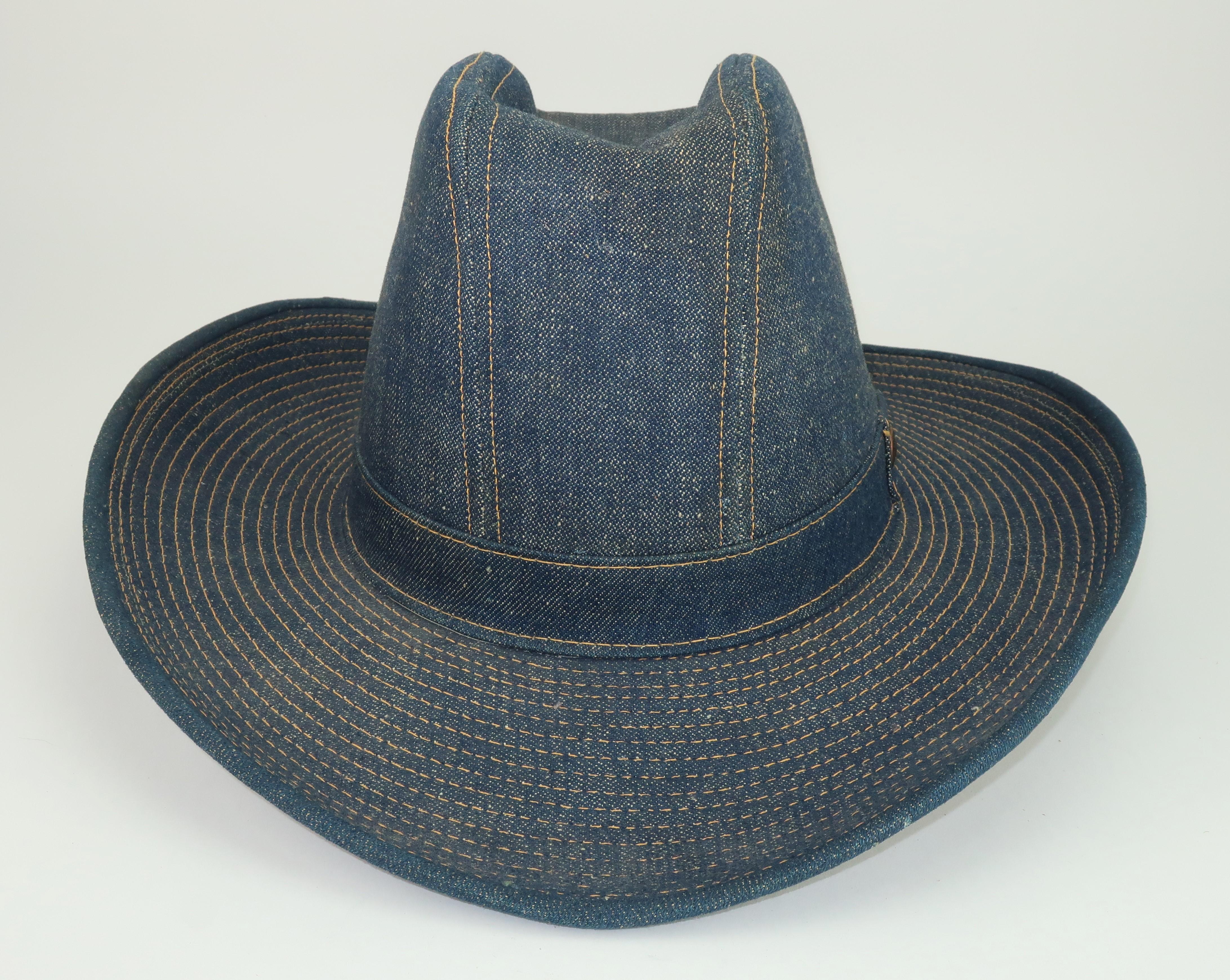 Late 20th Century Levi Strauss denim cowboy hat with iconic contrast stitching and a Levi's rivet at the band.  The hat has an old school hard body with satin lining and the Levi's gold foil label to the interior.  All the details of the Americana