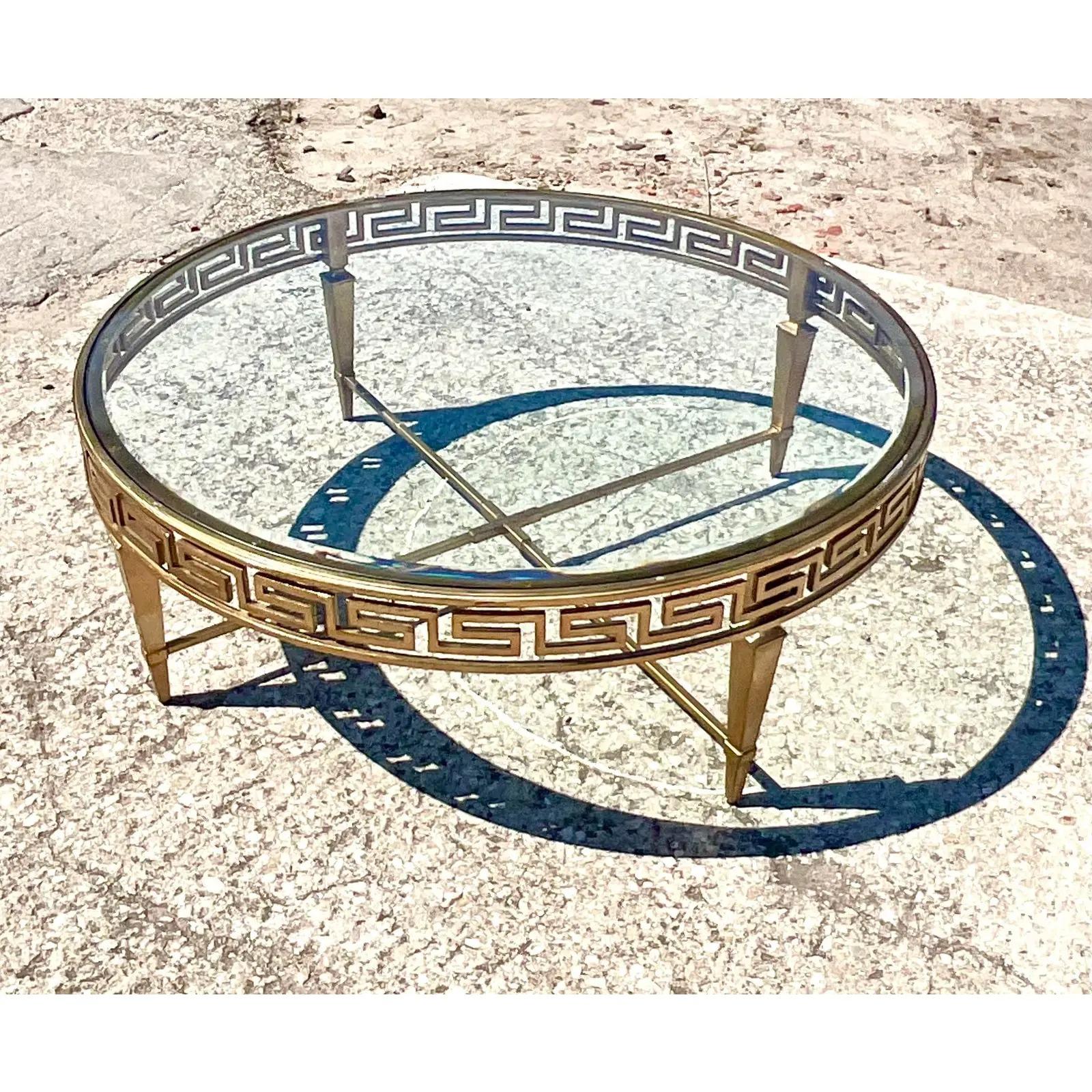 Stunning vintage Lexington Regency coffee table. Beautiful Greek Key design on a round gilt frame. A chic warm silver fining. Beveled glass inset. Acquired from a Palm Beach estate.