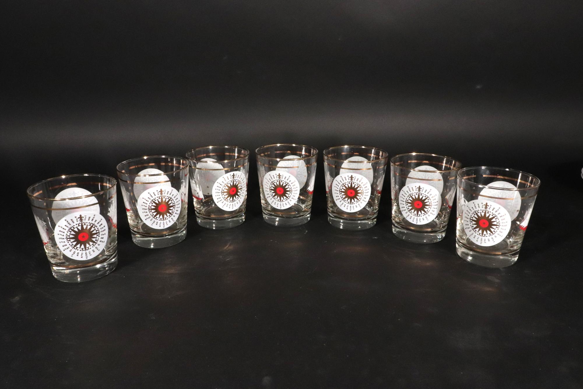 Bicchieri da cocktail doppi da sasso vintage in vetro Libbey Nautical,
Un set di sette,
1970s

I bicchieri sono decorati su due lati da una bussola bianca con i nomi dei punti della bussola in oro.  Sugli altri due lati ci sono due navi.  Una nave è