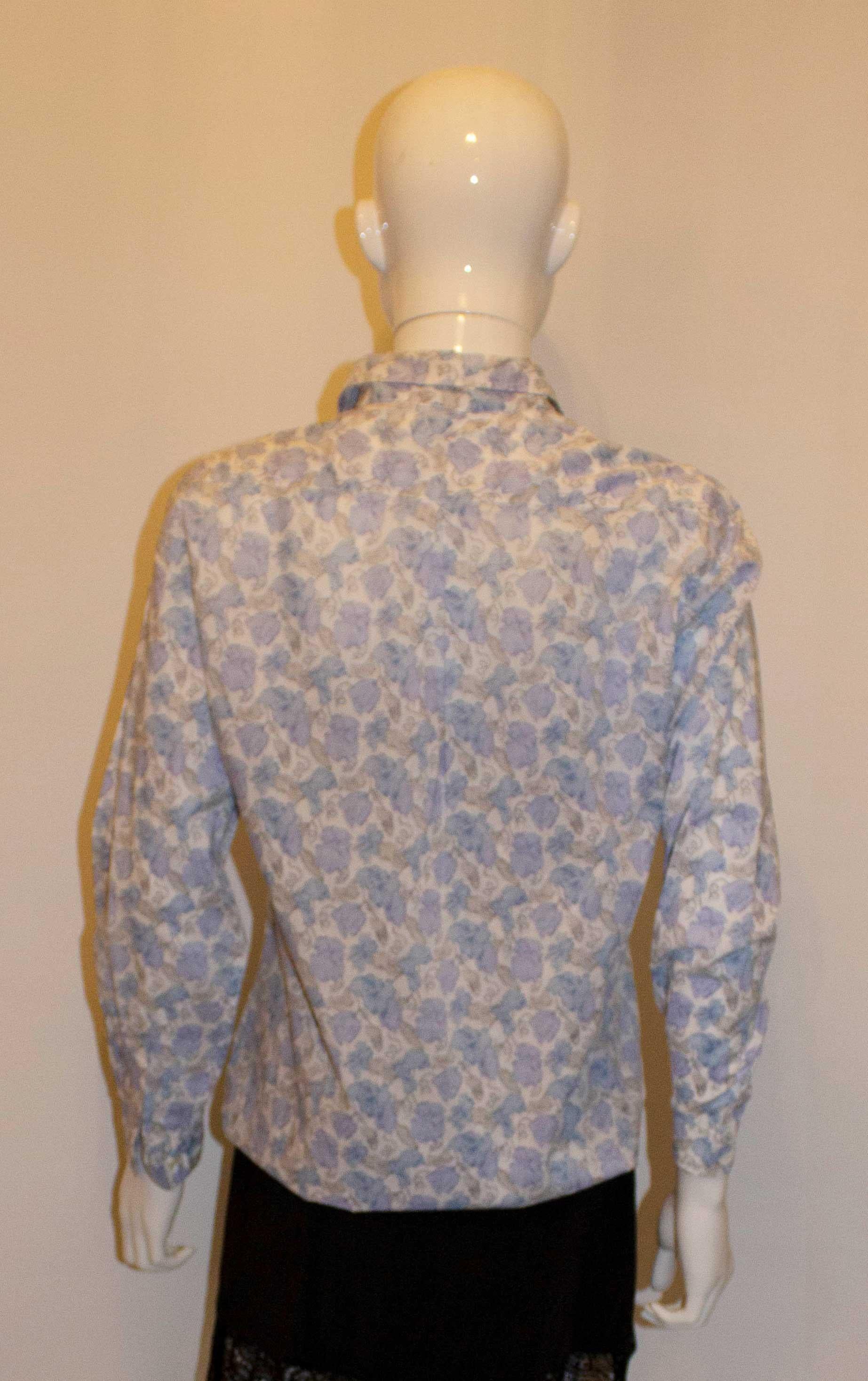 A very pretty vintage cotton shirt by Liberty / Cacharel.  The shirt is in a blue and white print, and has  a button front opening and pocket on the left hand side.  Made in Italy.
Measurements: Bust up to 38'', length 26''