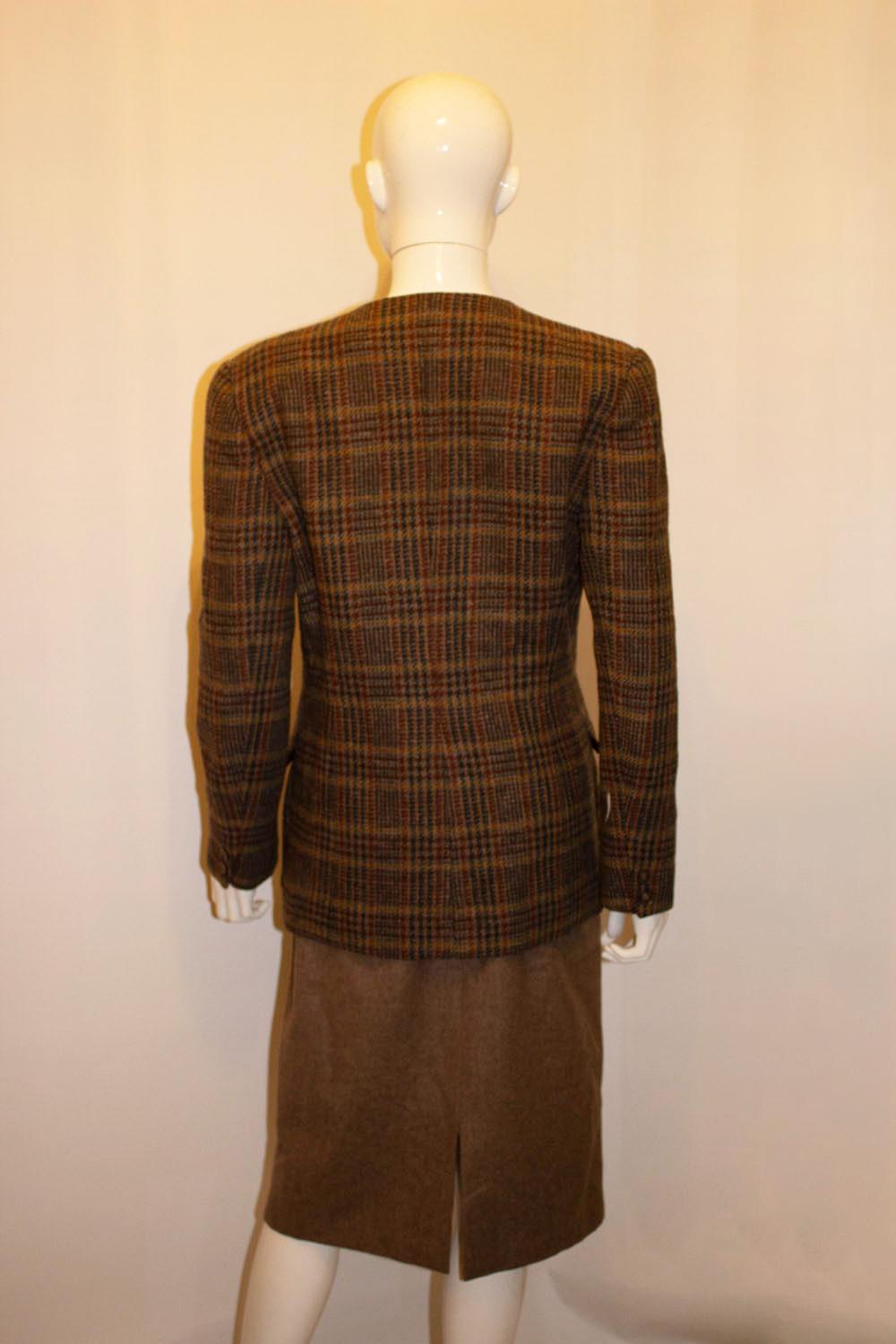 A wonderful vintage skirt suit by Liberty of London, the fabric as you would expect is of superb quality.
The jacket has a v shaped neckline with two button front opening and attractive detail on the pockets. The brown wool skirt has great belt