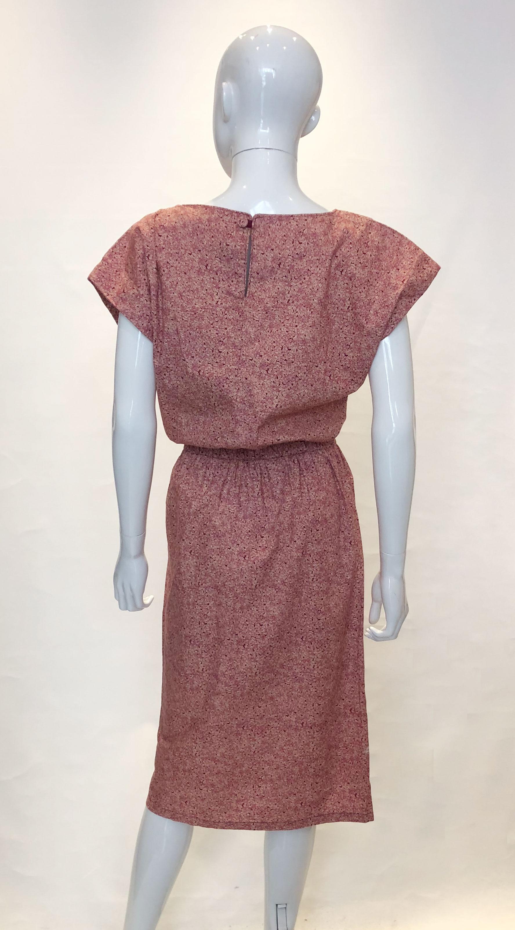 A pretty cotton print dress from Liberty.  In a plumb and cream print, the dress has a round neckline,button opening at the back and an elasticated waist.  The waist measuring from 28 -31.''.