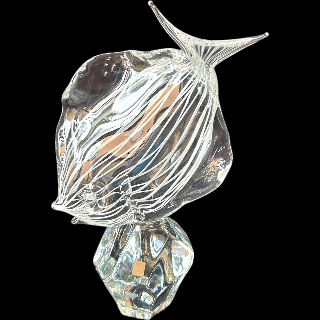 Questa bellissima statuetta vintage di Murano è un'opera d'arte straordinaria che non mancherà di arricchire qualsiasi collezione.  Realizzata dal famoso artista Licio Zanetti, questa statuetta fatta a mano presenta un motivo a strisce bianche e