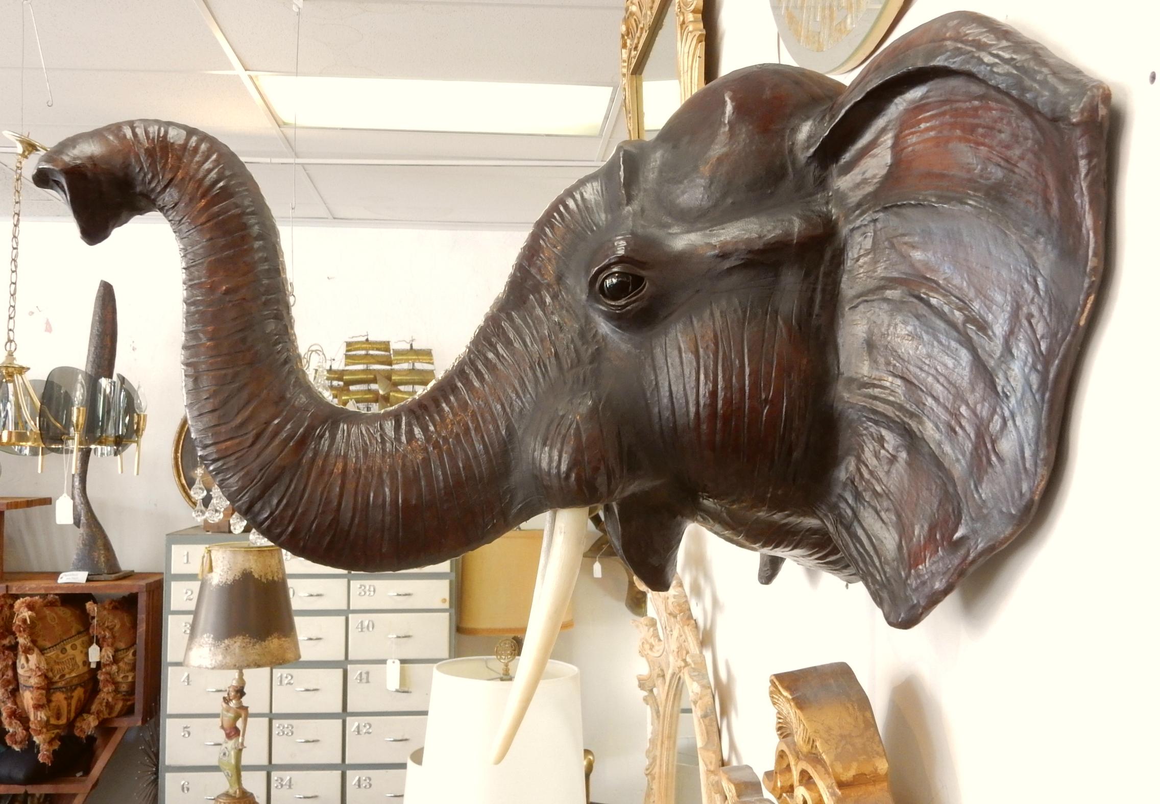 Perfect exotic eclectic decor piece for a large space.
This life sized elephant bust is adroitly clad in leather parchment over a wood form.
Fine realistic features include glass eyes and faux ivory tusks,
circa 1960s, not marked or signed by