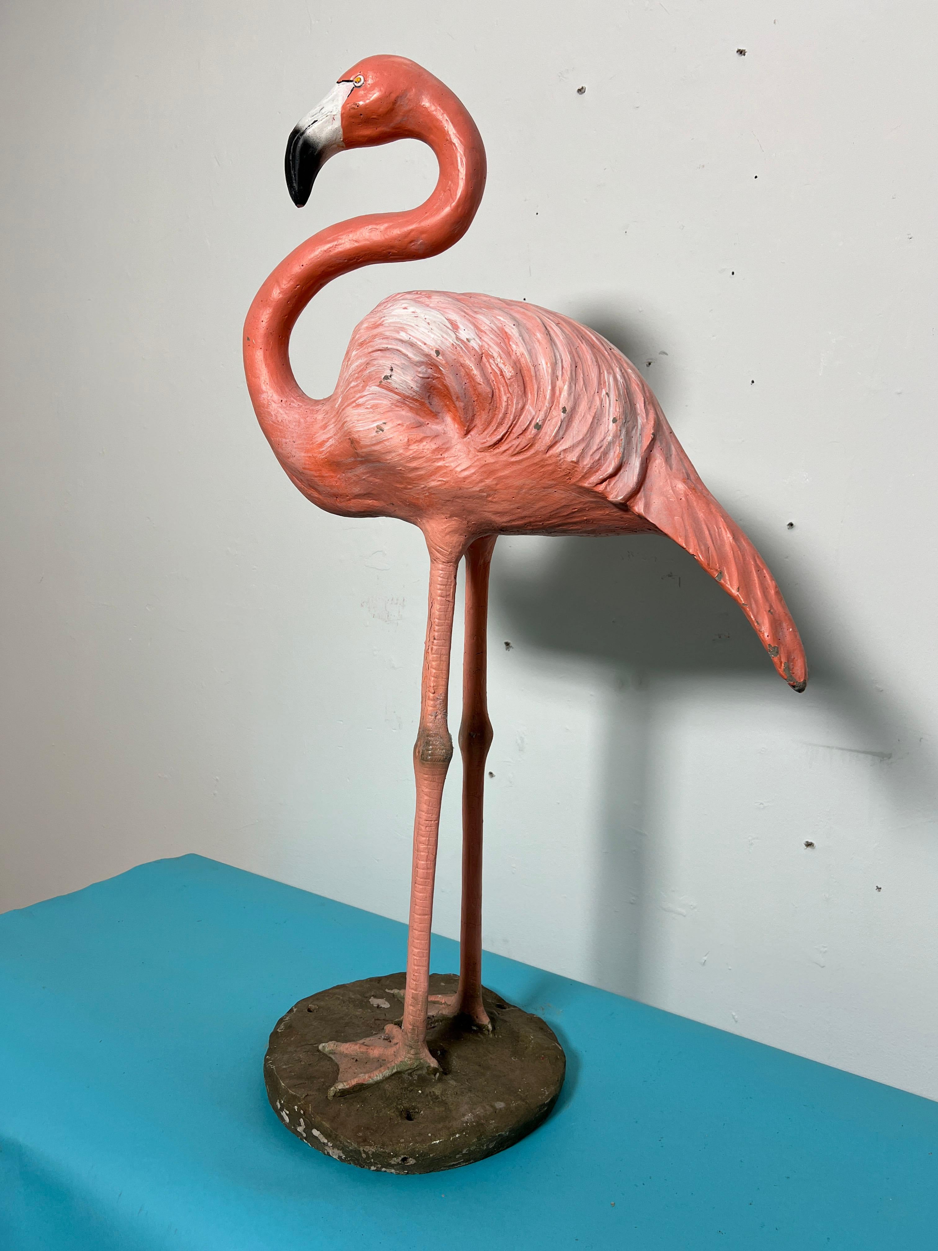 A classic life sized garden flamingo constructed of cast and painted stone over an ironwork armature.  Possibly of French origin.  We have not identified the maker's mark on bottom.   Includes a pair of original lawn stakes.
