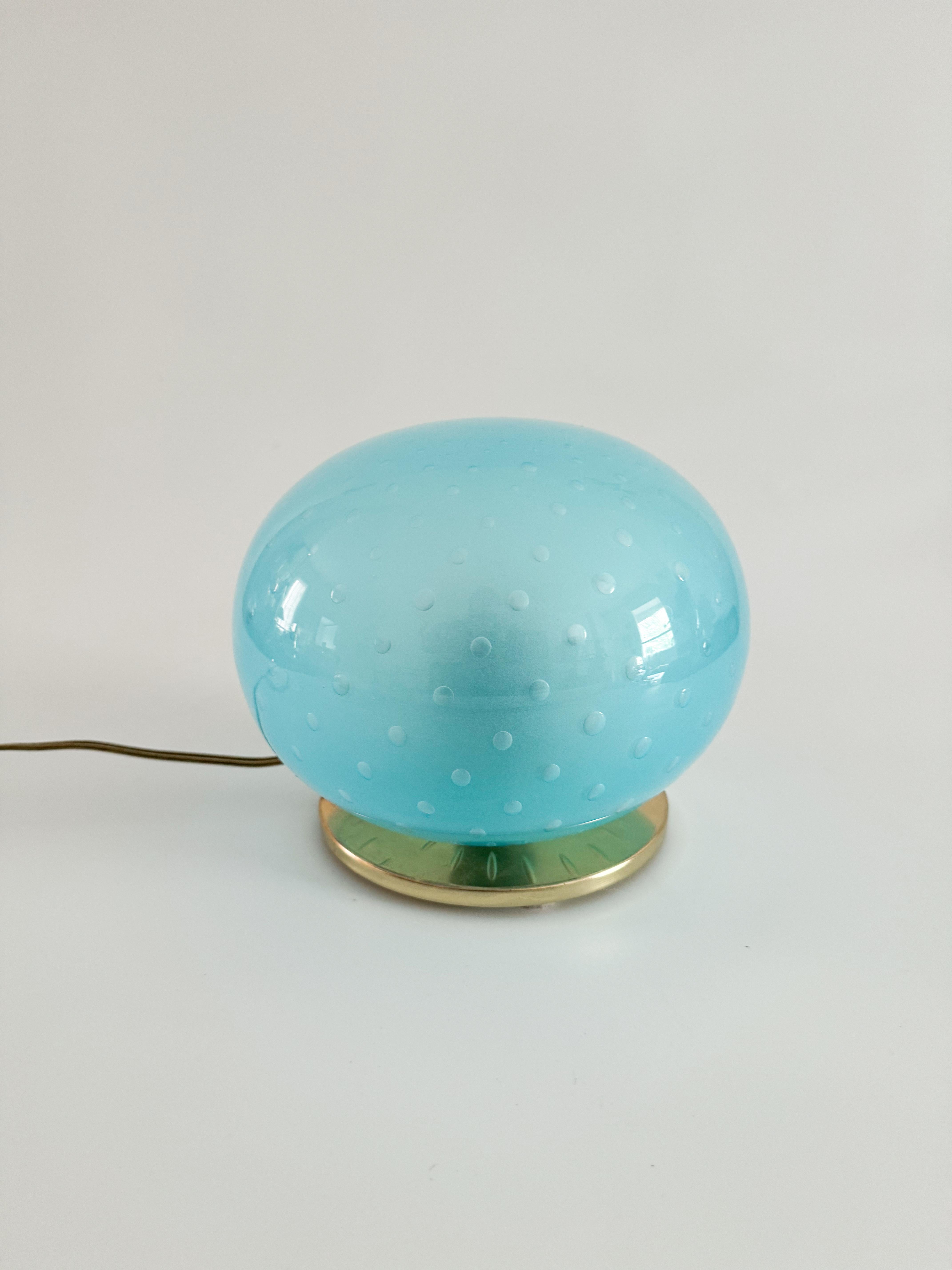 This vintage blue sphere table lamp, crafted in the 1970s, features a stunning light blue handblown Murano glass sphere. The glass, in perfect condition with no chips or cracks, showcases a rare and hard-to-find design, created using a complex