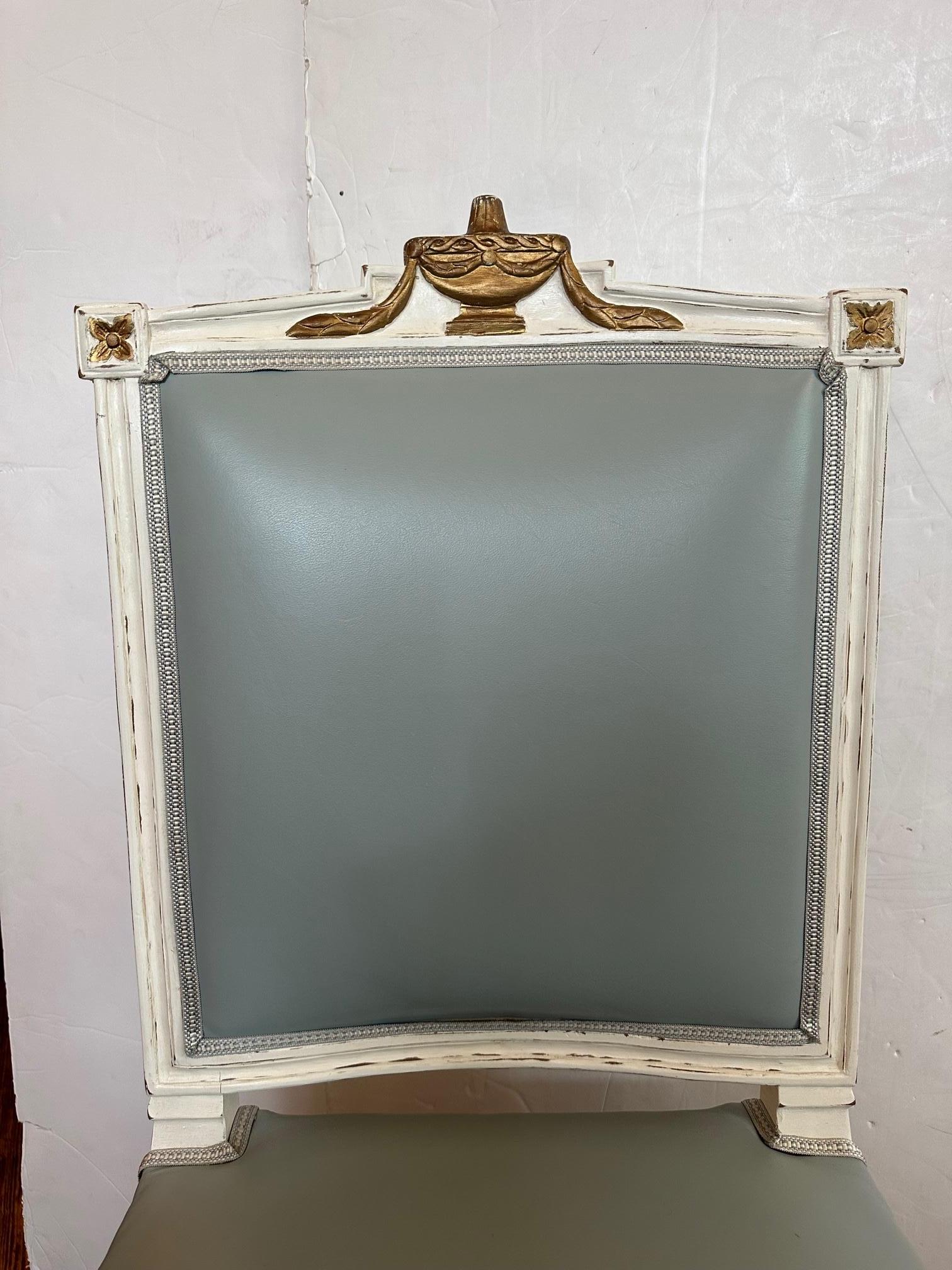 Very pretty French style side chair having powder blue leather upholstery and coordinating striped silk fabric on the back. The wood is painted white having elegant brass decoration, including an urn shape at the top, rosettes, swag on the front