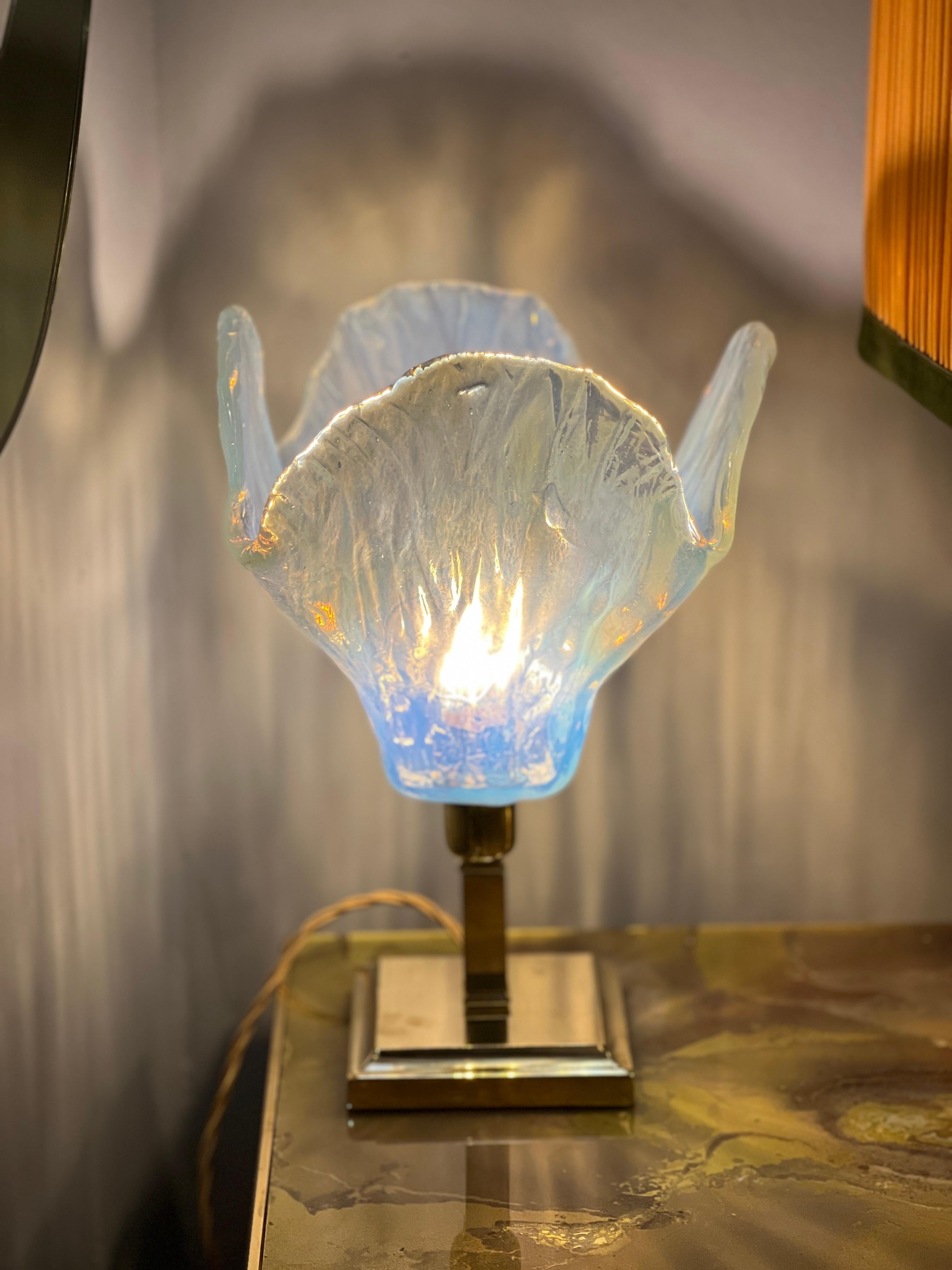Vintage light blue Murano glass flower table lamp with brass squared base.
The hand-blown light blue Murano glass has an amazing opalescent effect from light blue to amber tones.
One light bulb.
