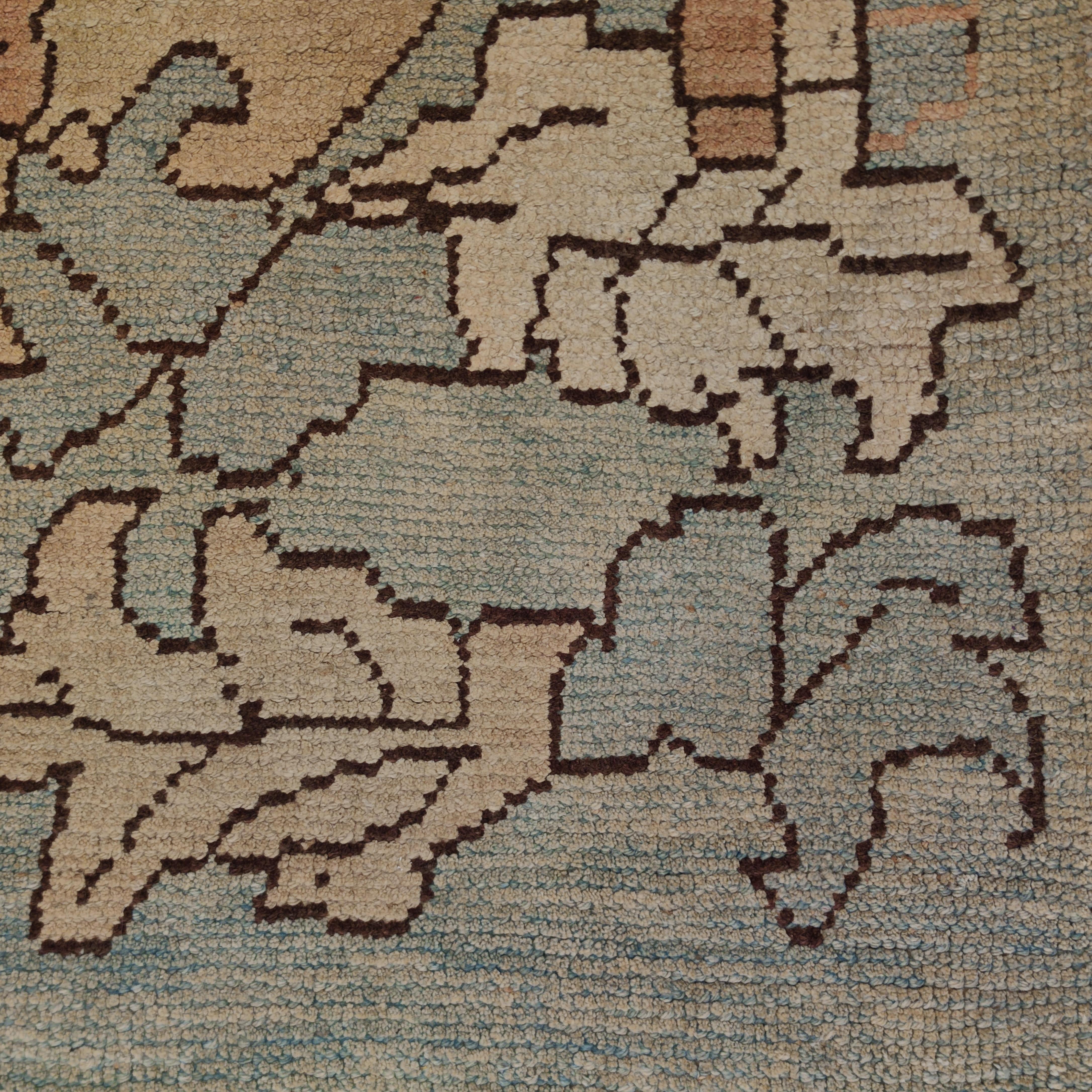 Ce tapis Oushak très raffiné se distingue par un magnifique fond bleu aqua, embelli par un motif surdimensionné composé d'une grande palmette centrale flanquée d'un réseau de feuilles finement dessinées. Les motifs de ce type découlent de la riche
