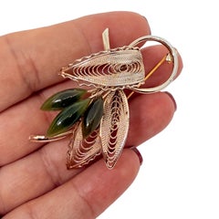 Broche vintage en pierres naturelles de jade vertes et dorées.