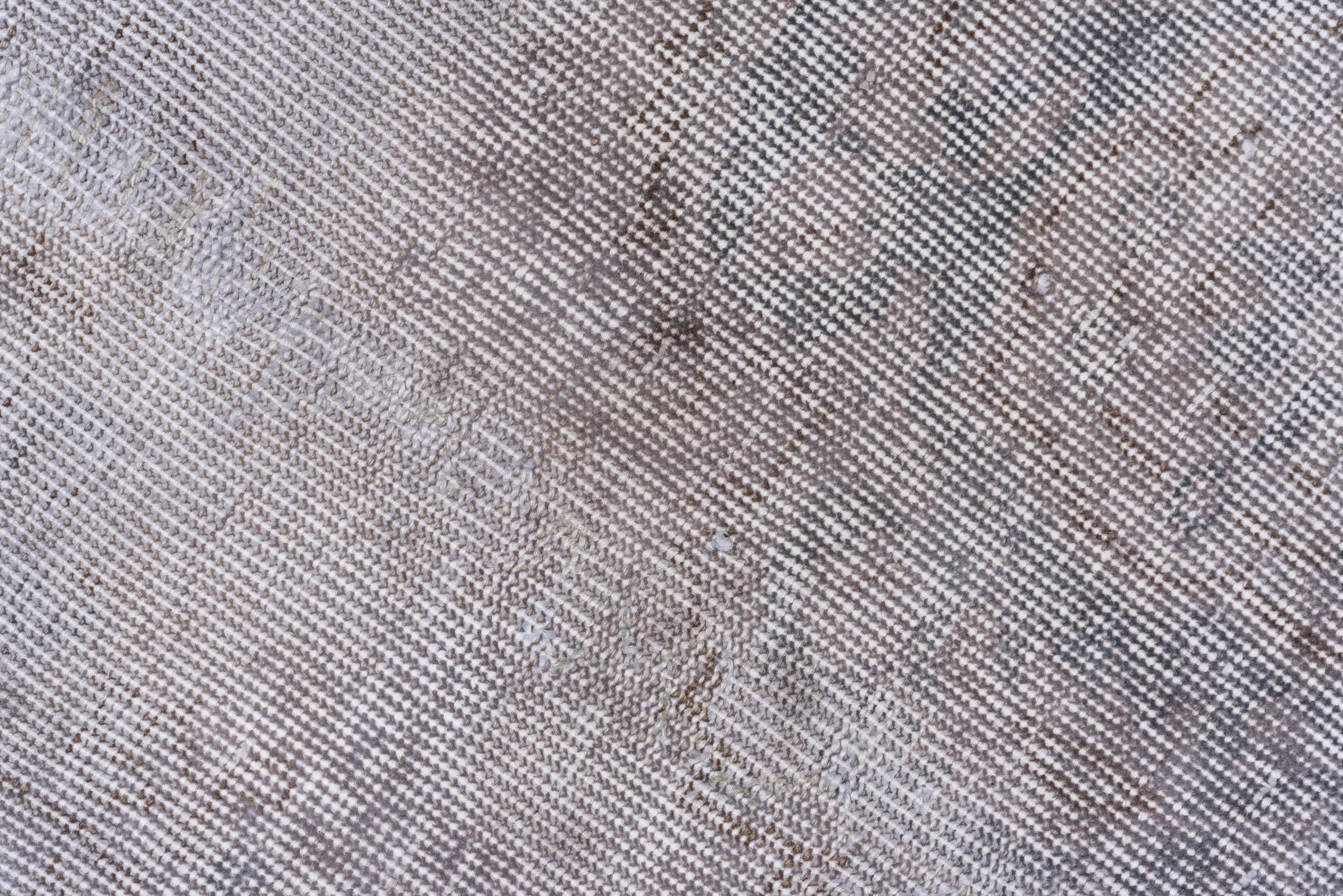 This light gray Turkish overdyed Sparta carpet has a pattern defined by the wear beyond the all-over general distress. Vertical and horizontal off-white strips cross near the center. Shabby chic conditions and can offer some great texture for floor