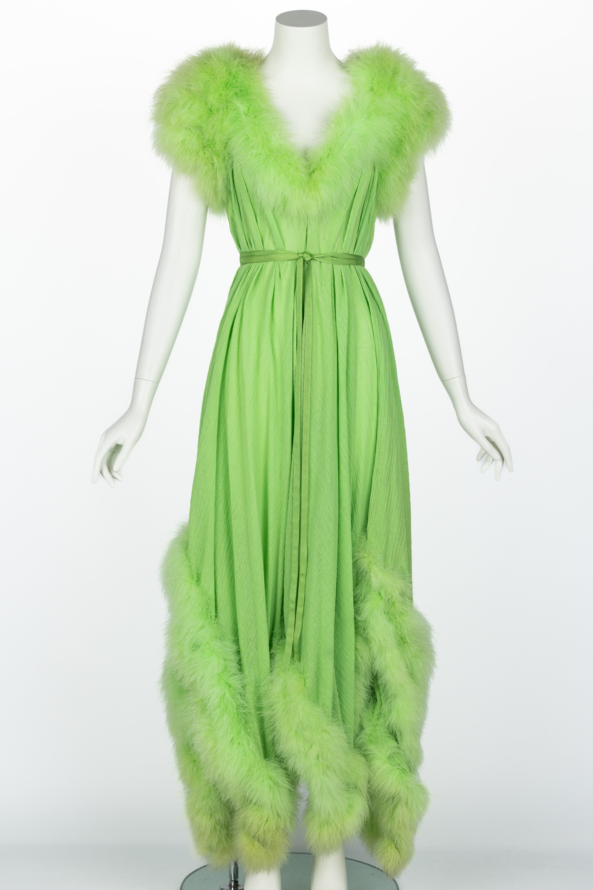 This fabulous vintage maxi dress hits all the right notes. Done in a light green fabric that feels like a cotton/linen blend, it effortlessly evokes the sensual glamour of the 1950s while exuding a timeless femininity. The design begins with a deep