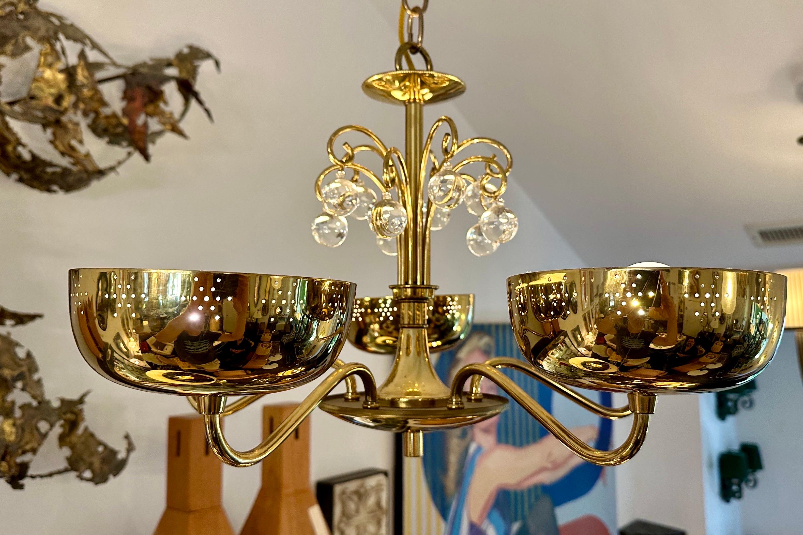 The 5 brass cup style diffusers are perforated with stars design.  This is a flush mount light fixture with crystal orbs adornments.  Made by Lightolier, possibly by Paavo Tynell.  THIS ITEM IS LOCATED AND WILL SHIP FROM OUR EAST HAMPTON, NY