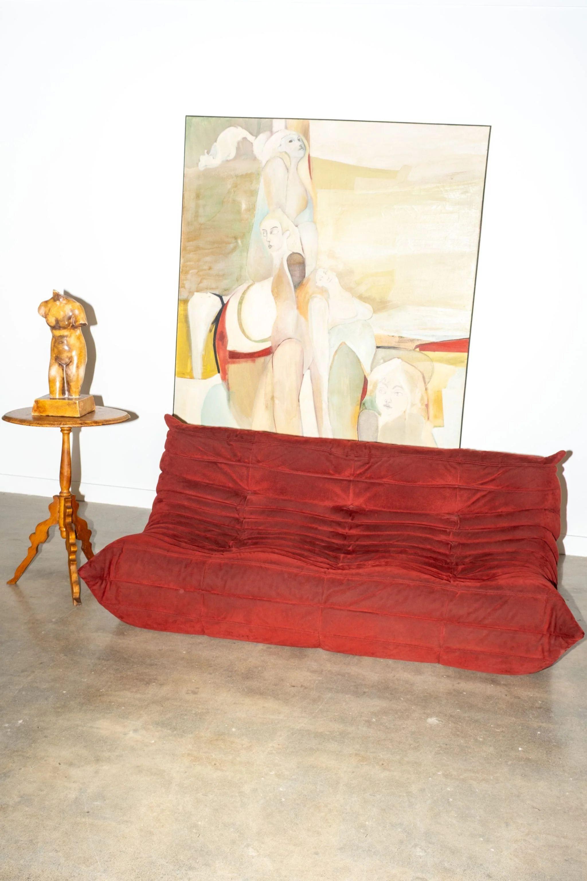 A design icon with undeniable charm, this three-seater Togo sofa by Michel Ducaroy for Ligne Roset has been turning heads since its 1973 debut. Upholstered in a plush red fabric, its low-slung, pillow-like form and distinctive pleated structure are