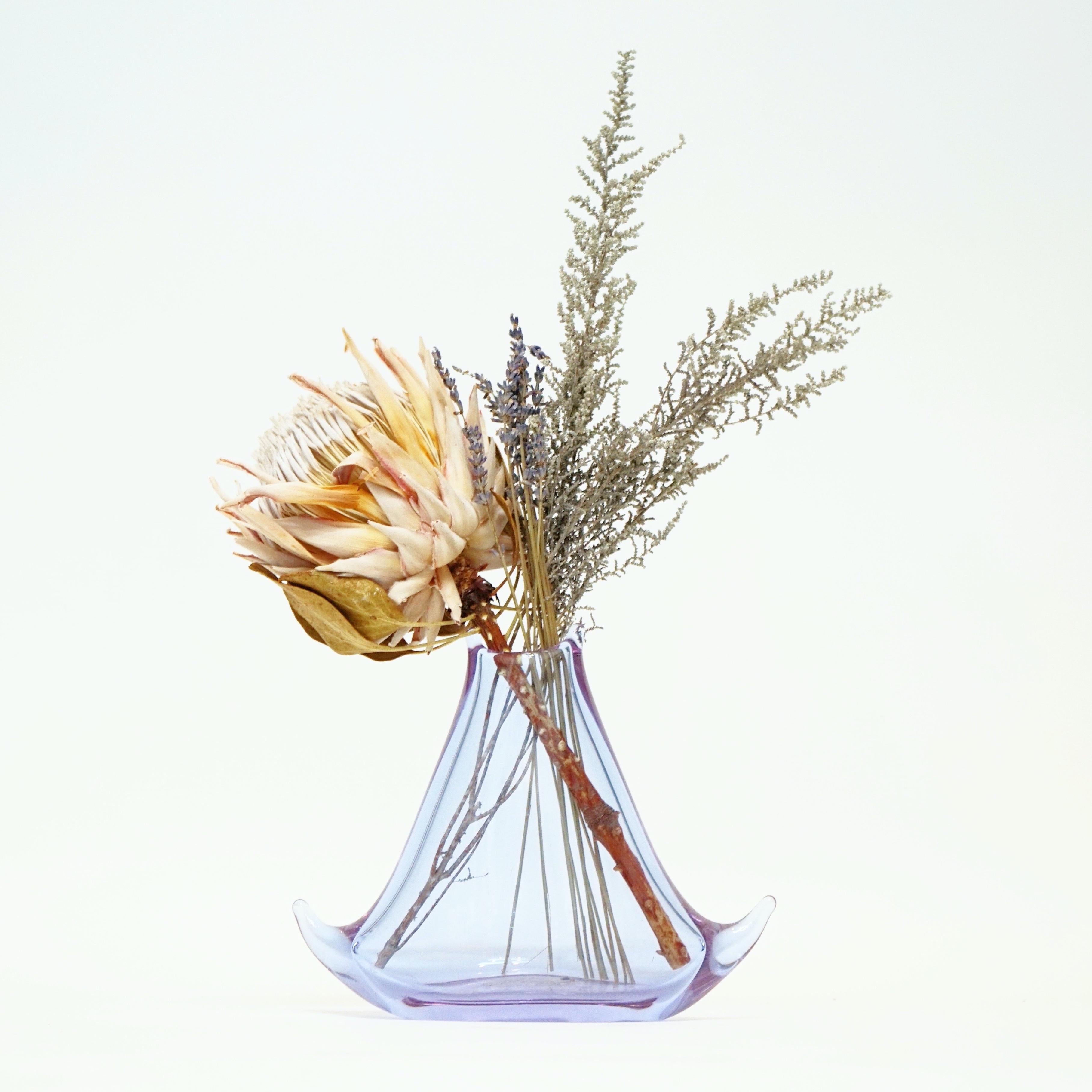 This whimsical vintage Murano glass vase is the perfect way to add a pop of color to your space. Perfect for showcasing dried flower arrangements, excellent in a powder room or entry.

Details:
- Transparent lilac purple Murano glass
- 9.5