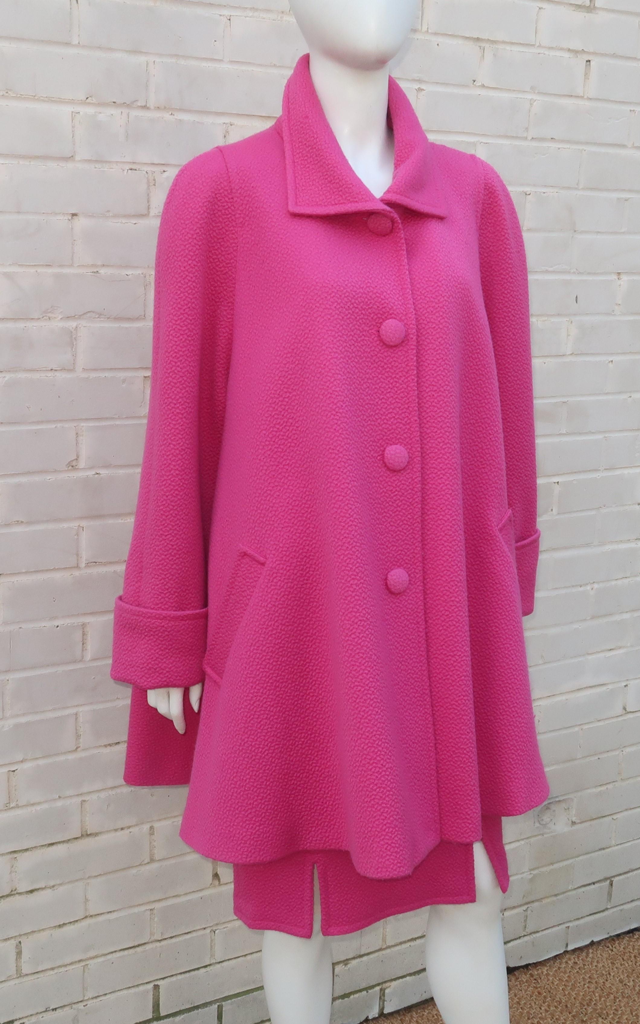 A 1980's hot pink wool pique suit by French label, Liliane Burty, including a straight skirt with front and back vents topped by a swing coat style jacket.  The skirt buttons and zips at the back.  The jacket has covered buttons down the front with