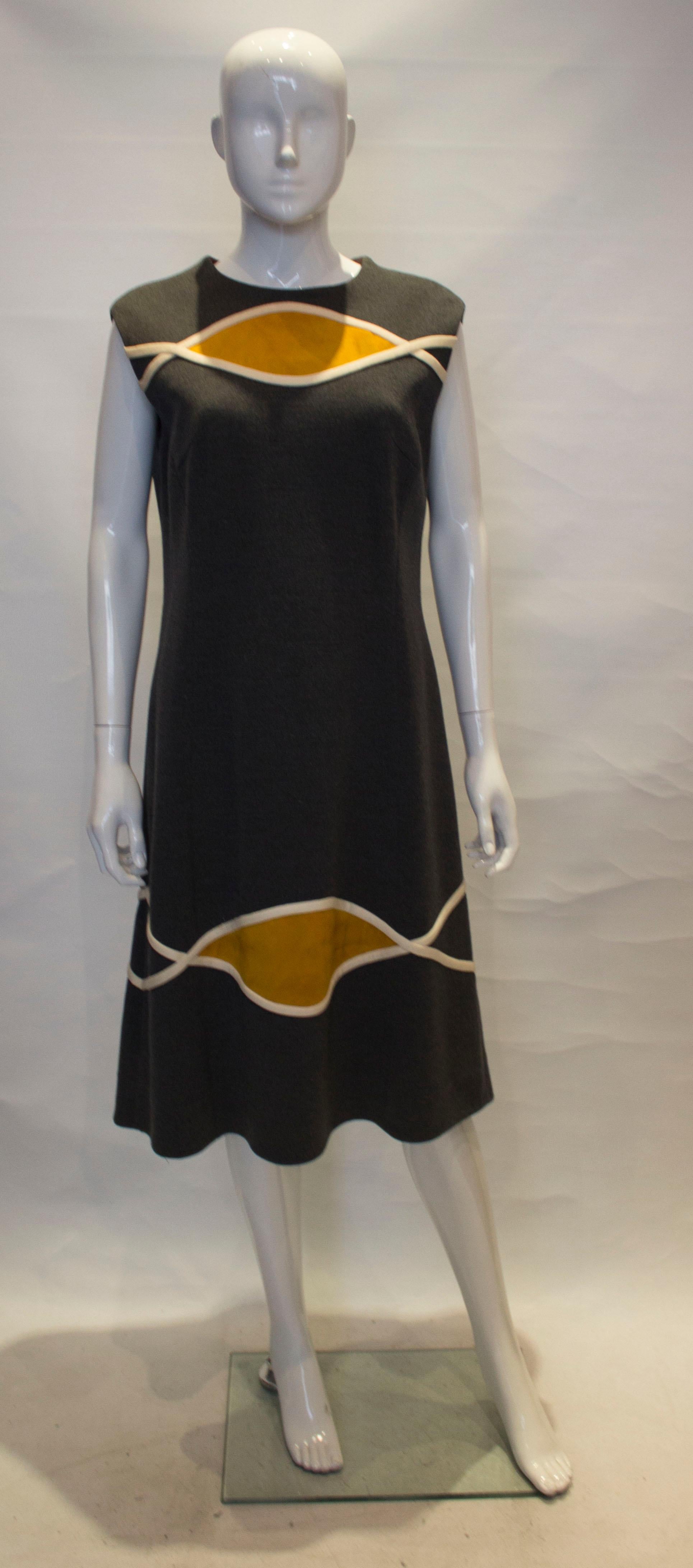 A stunning vintage dress by Lilli Ann, knit line. The dress is in a grey jersey with yellow suede detail. It is sleaveless , with a round neck,  and is fully lined.

The coat has a wide collar with suede detail, a button opening at the front and a