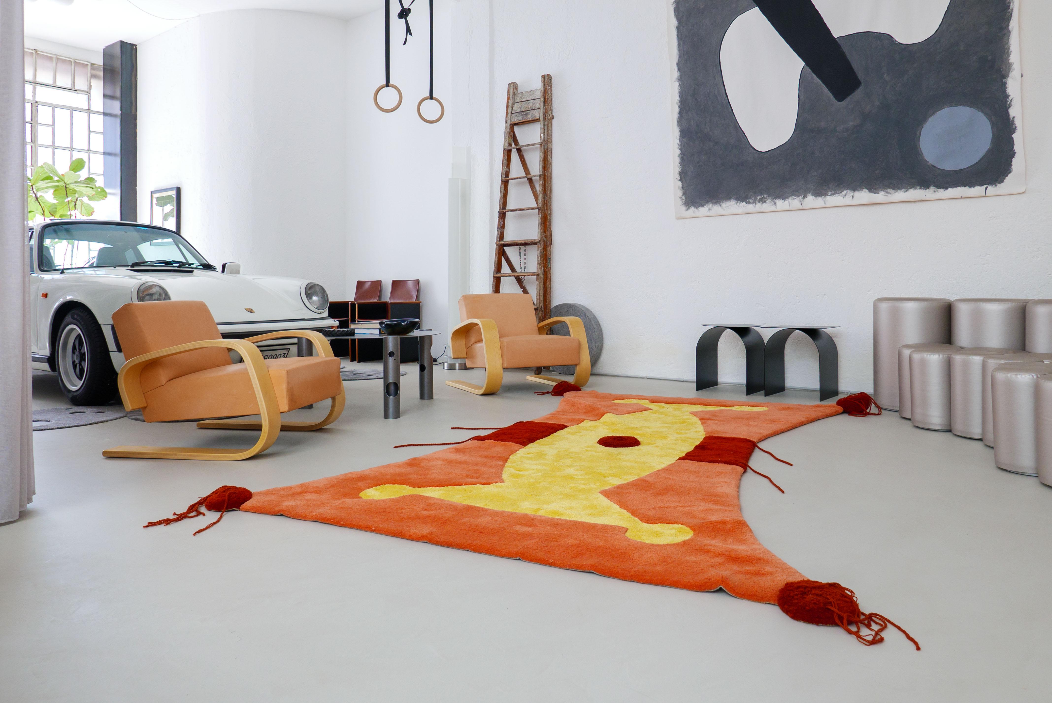 Vintage wool rug, designed in 1990 by Claude Picasso, son of Pablo, and manufactured by Danish brand Rapsel. The rug, hand-knotted in vibrant tones of salmon, yellow and burgundy wool, is extremely wide - measuring 3 by 2 meters. It is preserved in