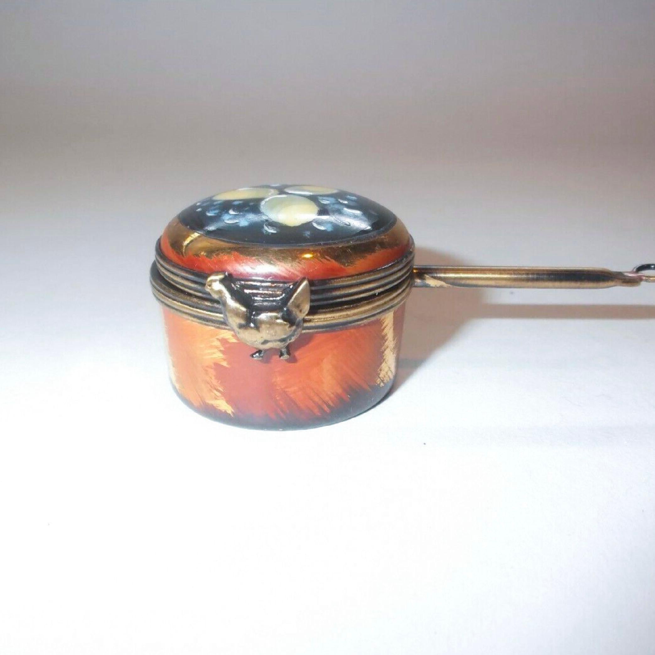 Midcentury handmade Limoges miniature - Copper color saucepan by Lagloriette, long handle with a hanging hook at the end the top of the box is painted with three eggs surrounded by boiling water. The clasp is in the form of a hen. Inside are two