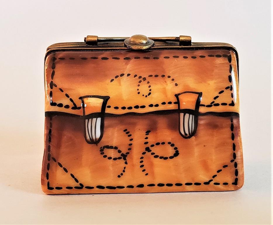 Presenting a lovely and exceptionally cute vintage Limoges leather briefcase box.

Made in Limoges, France, circa 1950-1960.

Marked on inside as “Limoges France … Paint Main … CHAMART Exclusive”.

‘Paint Main’ meaning hand painted and Chamart