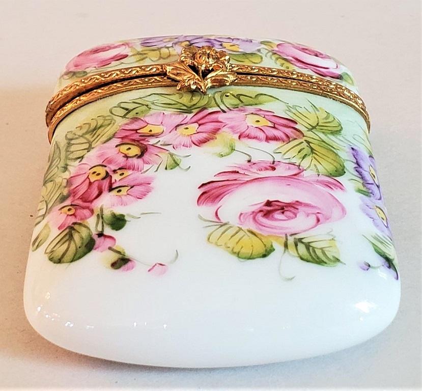 Presenting a lovely and exceptionally cute vintage Limoges purse shaped box.

Made in Limoges, France circa 1900-20.

Marked on interior as “Limoges France …. Peint Main .. CT”.

‘Peint Main’ meaning hand painted.

Beautiful pink and purple