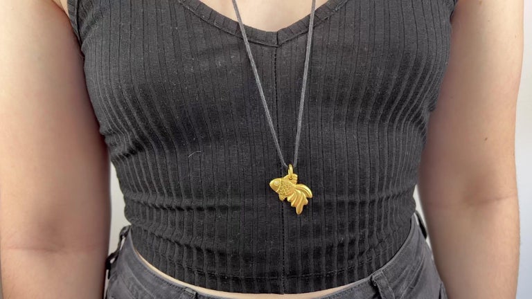 One Vintage Linda Lee Johnson Diamond 21 Karat Gold Cord Goldfish Necklace. Featuring one round brilliant cut diamond of approximately 0.02 carat, graded E color, VVS clarity. Crafted in 21 karat yellow gold, with Linda Lee Johnson maker's mark.