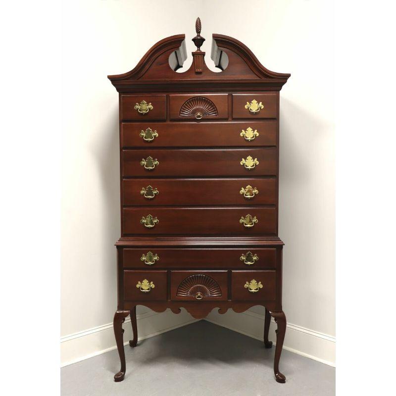 A highboy chest in the Queen Anne style made by Link-Taylor, from their Heirloom Gallery. Solid mahogany with brass hardware, a full pediment top, center finial, cabriole legs and pad feet. Features eleven dovetail drawers of various sizes, two with