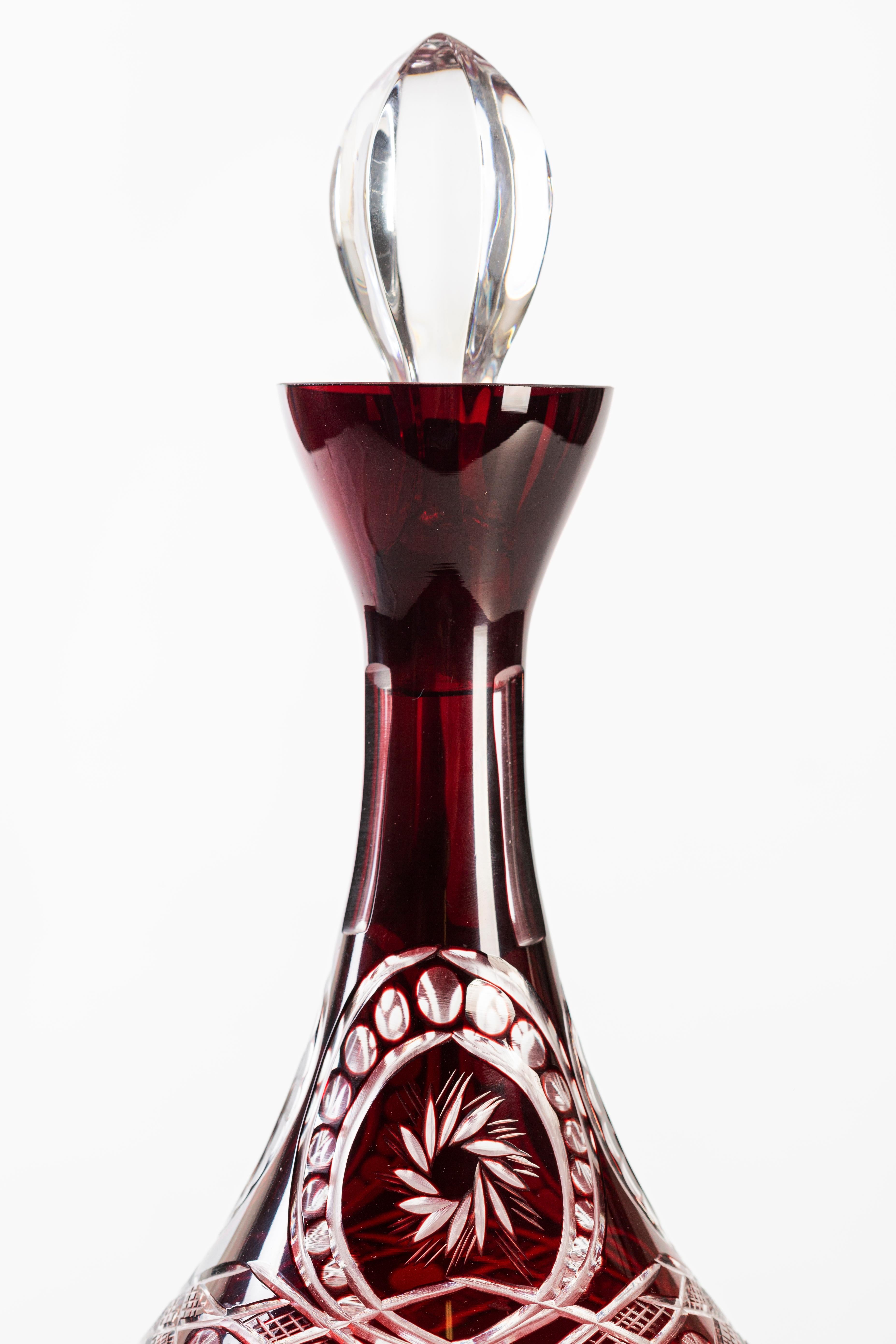 Liqueur set is an original decorative object realized in the 1930s in Bohemian glass.

This wonderful liqueur set consisting of a carafe and six goblets, clear glass bordeaux red overlaid, slender carafe shape on a round base with stopper, cut