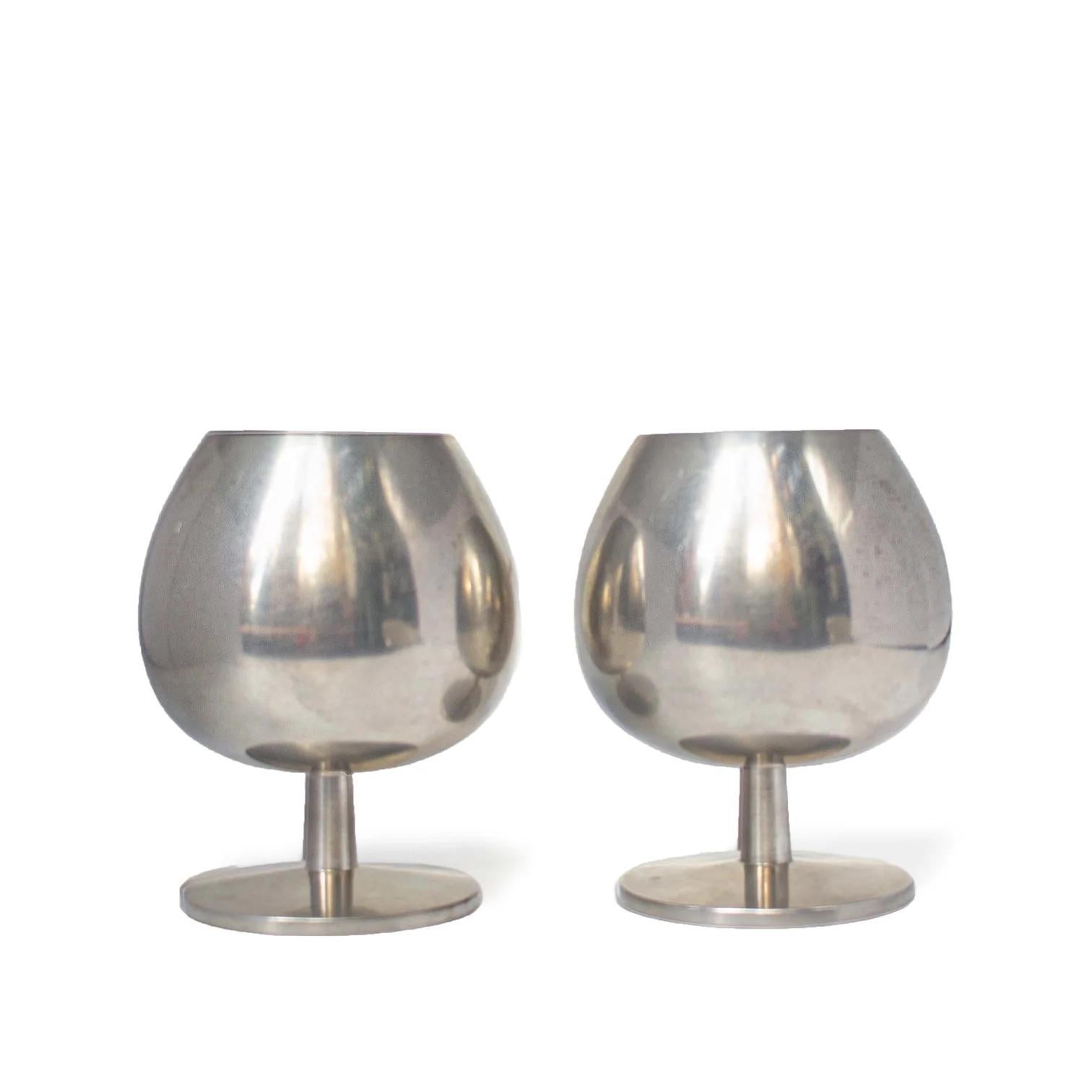 Liquour Goblets by Metawa Holland.

Made in the Netherlands.
Material: silverplate metal.
1960s.
Measures: 3 x 3.5 in / each.


Set of two metal cognac glasses. These goblets with a short stem and balloon rounded cup make the perfect glass