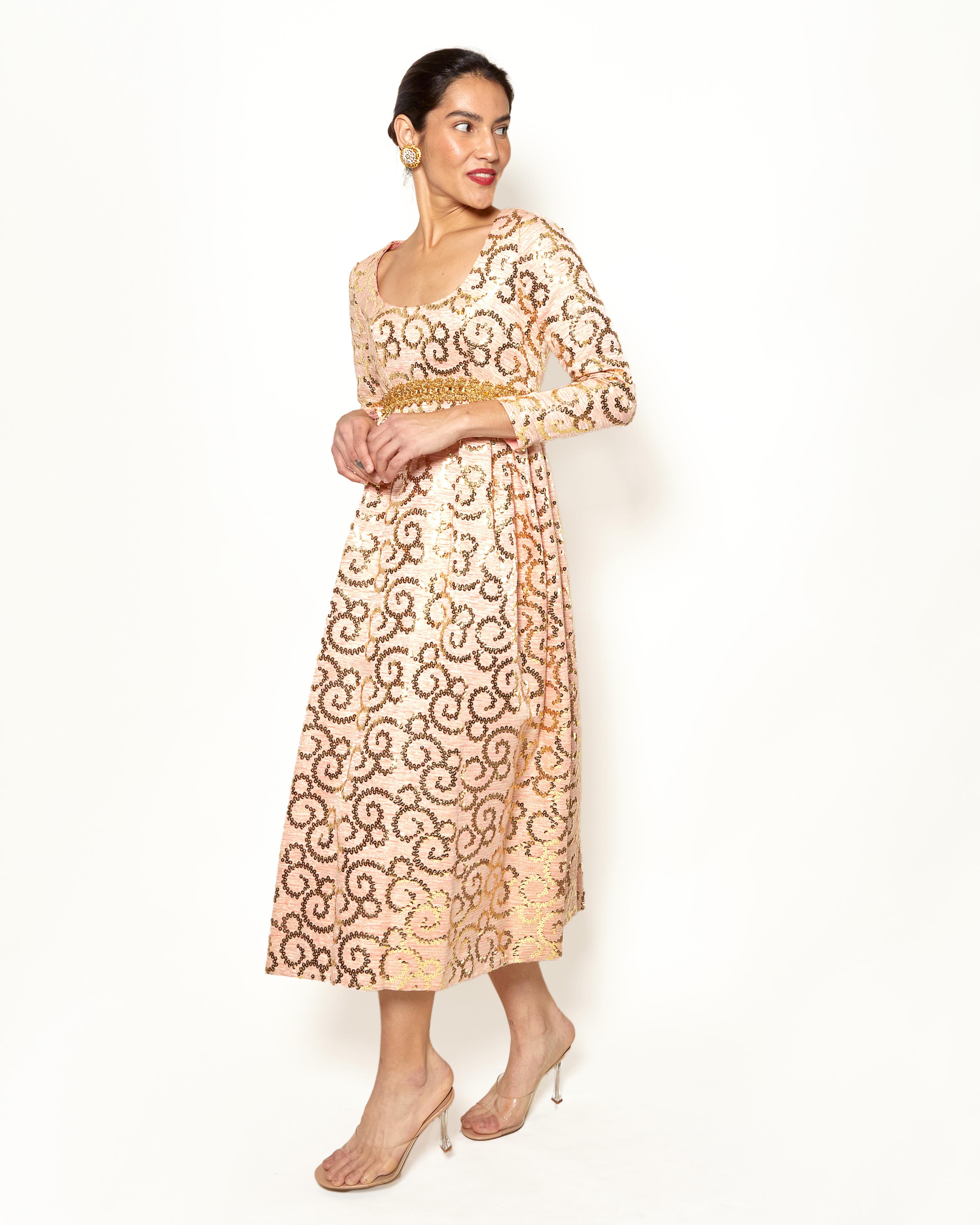 Préparez-vous à faire tourner les têtes dans notre robe vintage Lisa Meril couleur corail à paillettes dorées taille empire ! La taille empire et les paillettes dorées éblouissantes rendent cette robe parfaite pour tout événement formel de jour ou