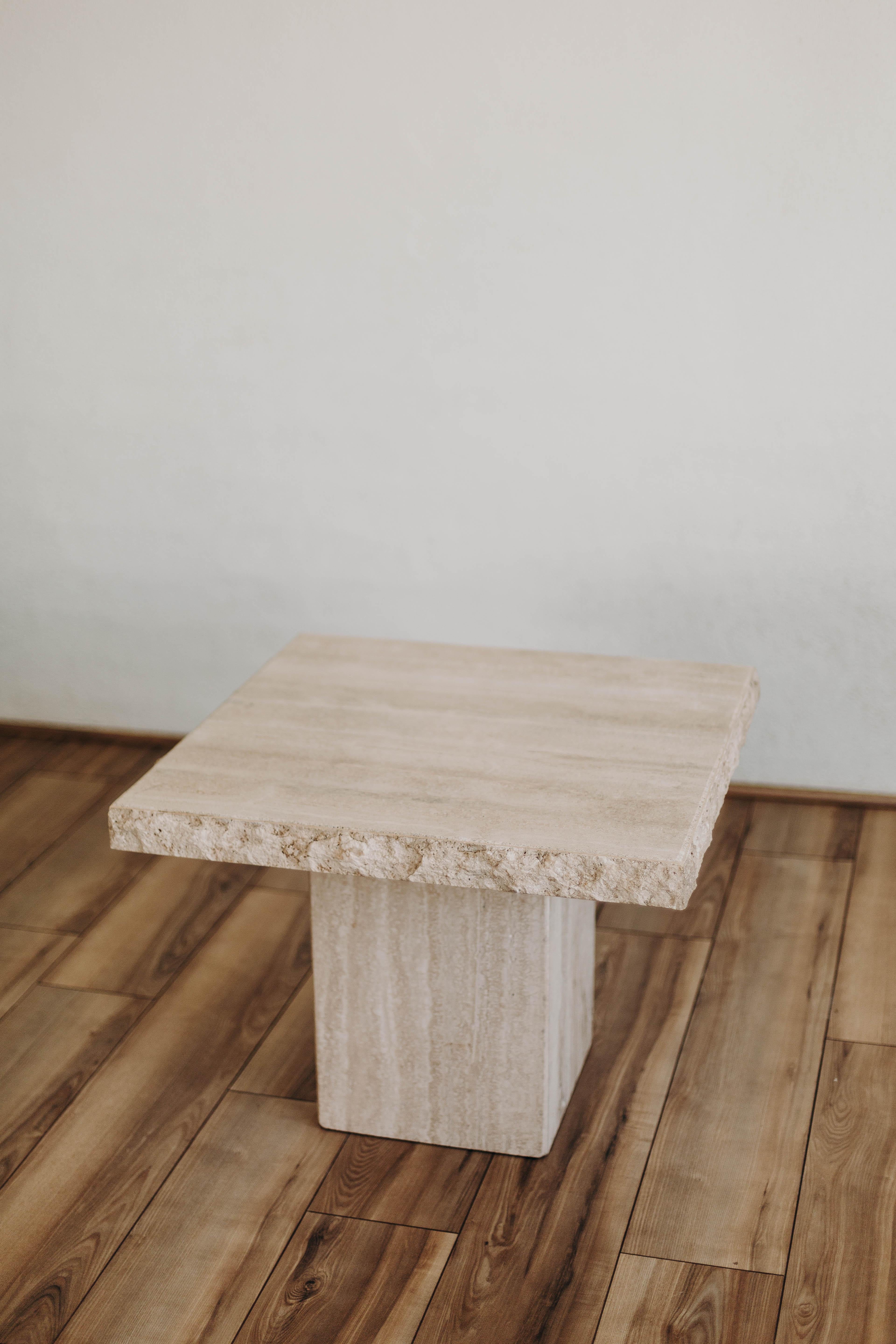 This travertine end table with a live edge is a stunning piece of furniture that effortlessly combines natural beauty with modern design. With a 27