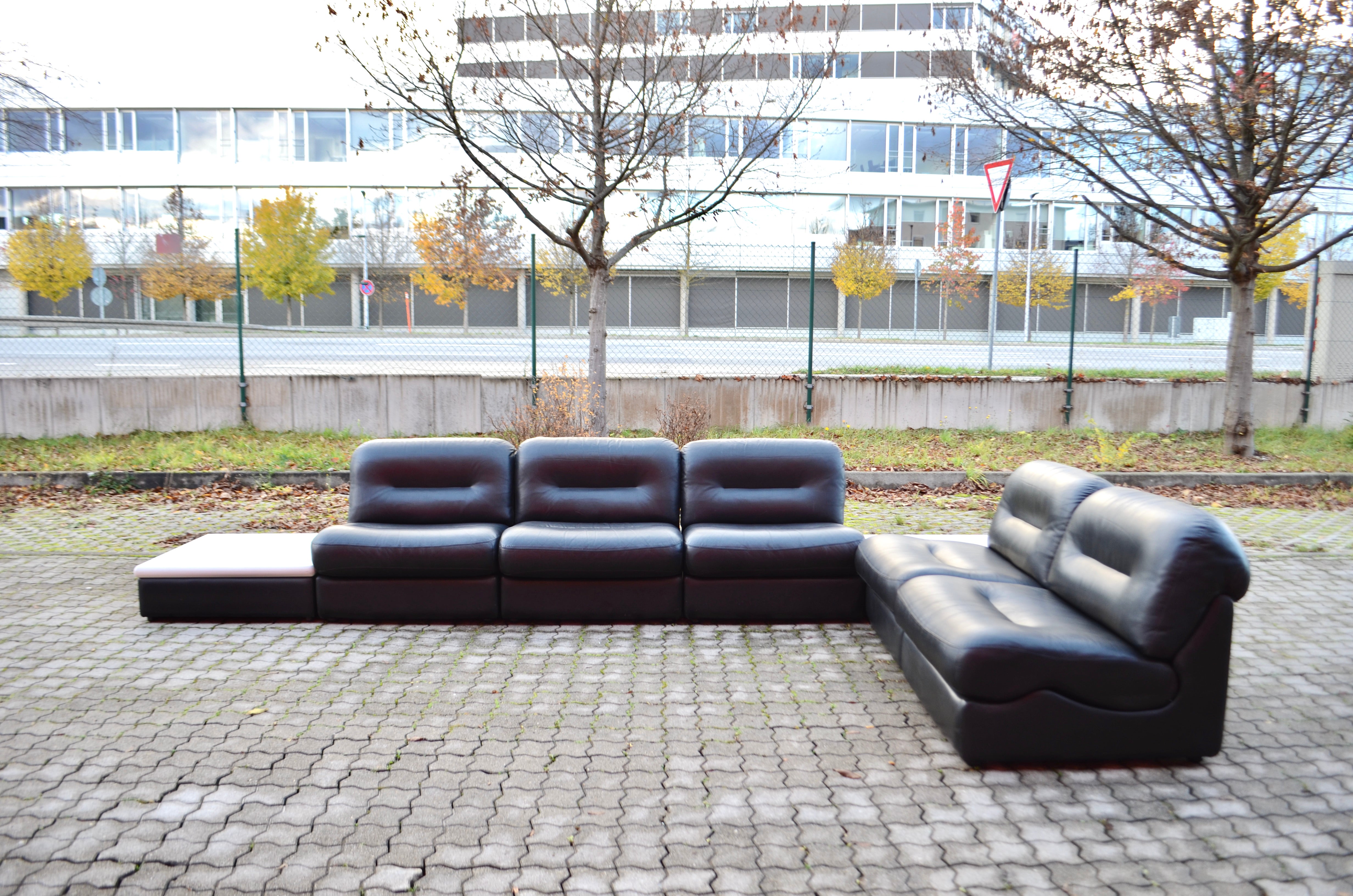 This stunning Modular sectional leather sofa was manufactured in Germany.
It is a pure 70ties design 
The frame of every element is made of wood and it is covered by foam and black leather.
The seating cushions can be removed.
This modular sofa