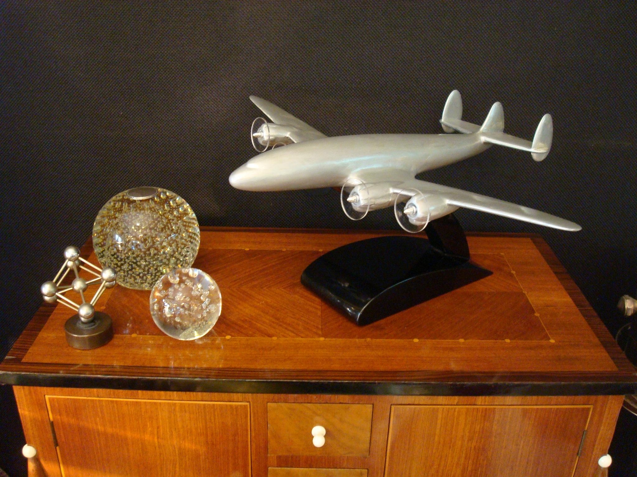 Vieille maquette d'aviation en métal peint montée sur une base en bois noir poli.
Le Lockheed Constellation (