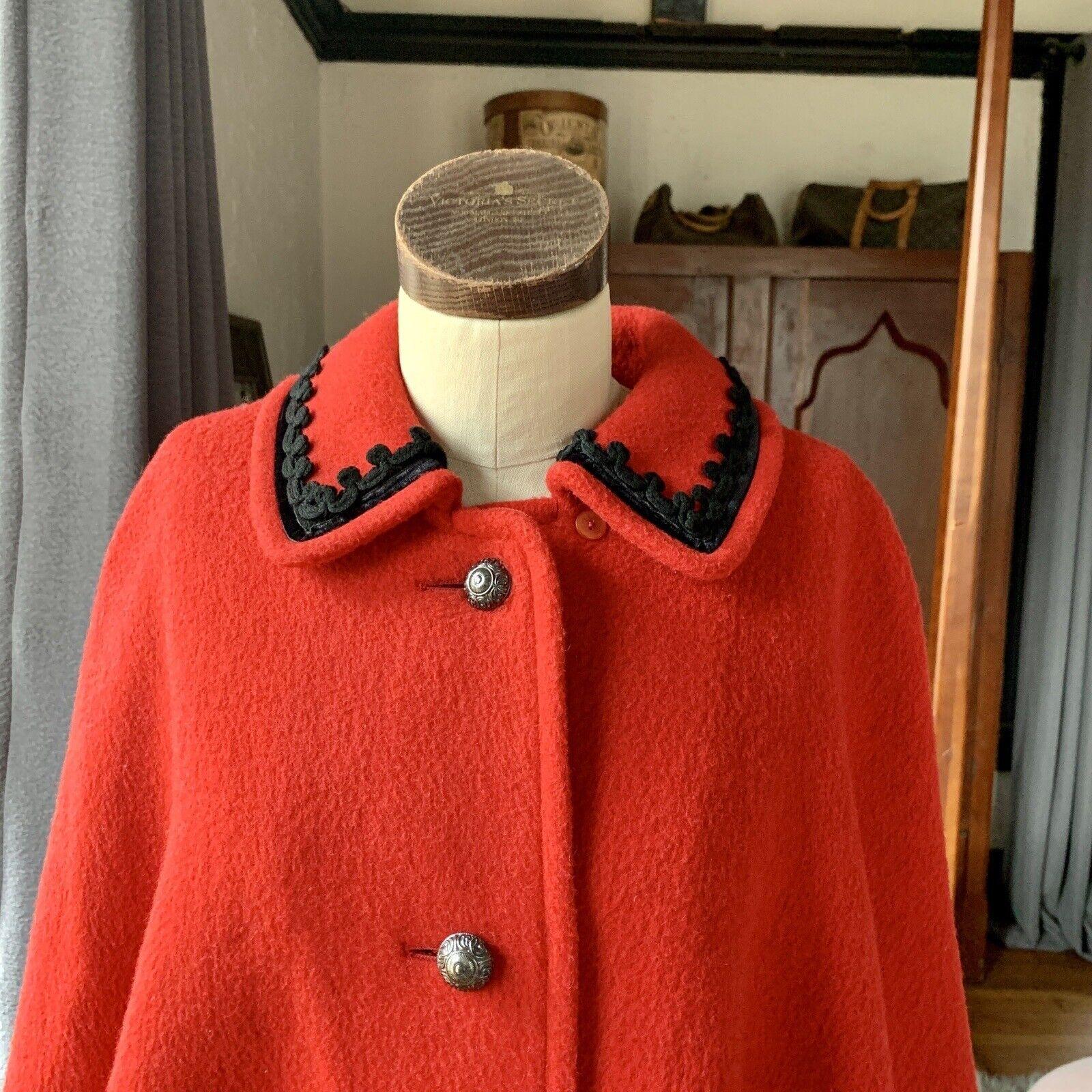 Logan Germany Cape, Wool Blend, Four Metal Buttons, Two Pockets (One Unopened), Velvet Trim on Bottom and Around Collar, Fully Lined, Size 40, Fun Vintage Label with Mountain Goat

Measurements Laying Flat

Length 31