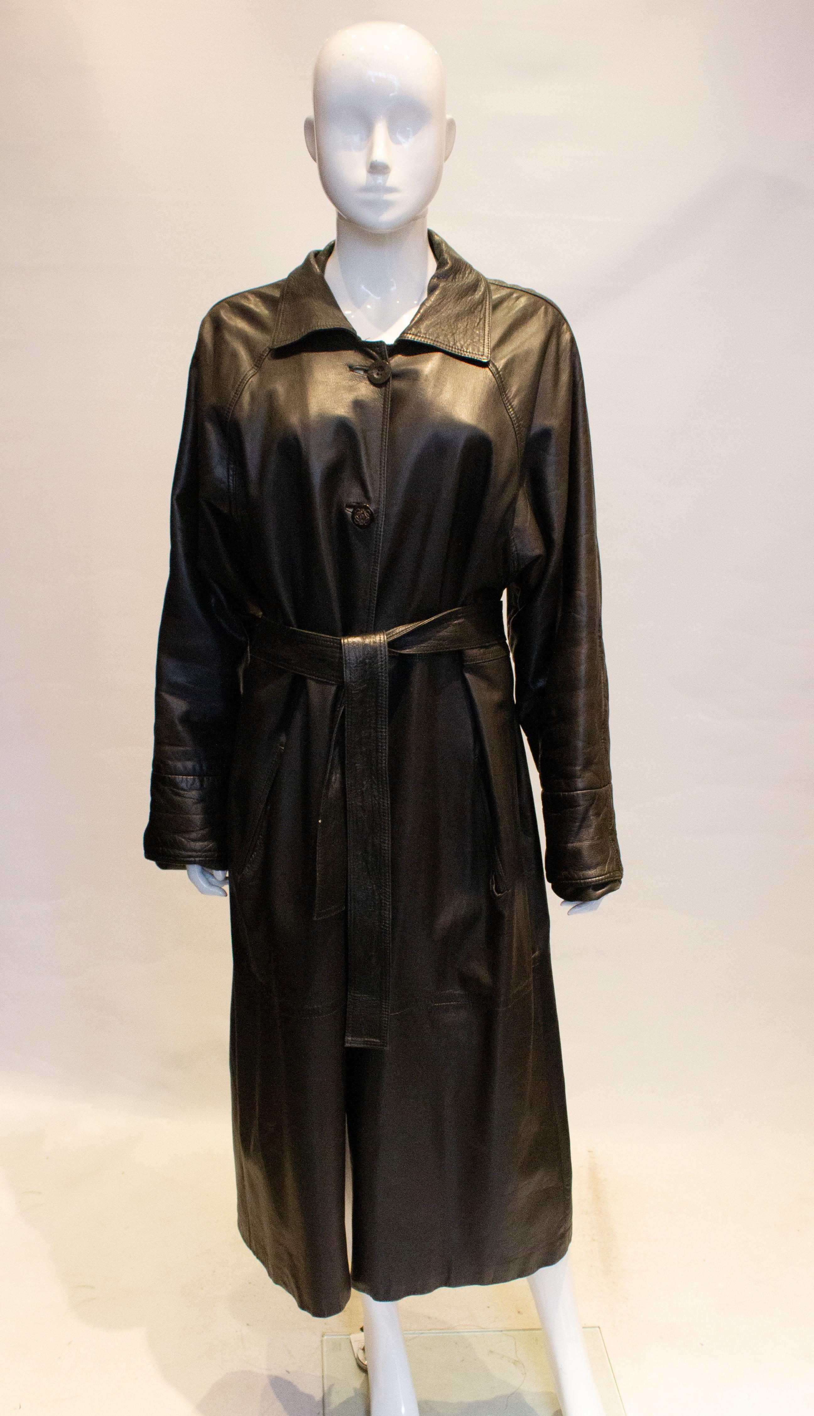 A head turning vintage black leather coat by Loewe. This coat is in super soft leather as you would expect from Loewe. It has a front button opening with internal button holes for a liner. It has two pockets, a back vent and matching belt.
The top