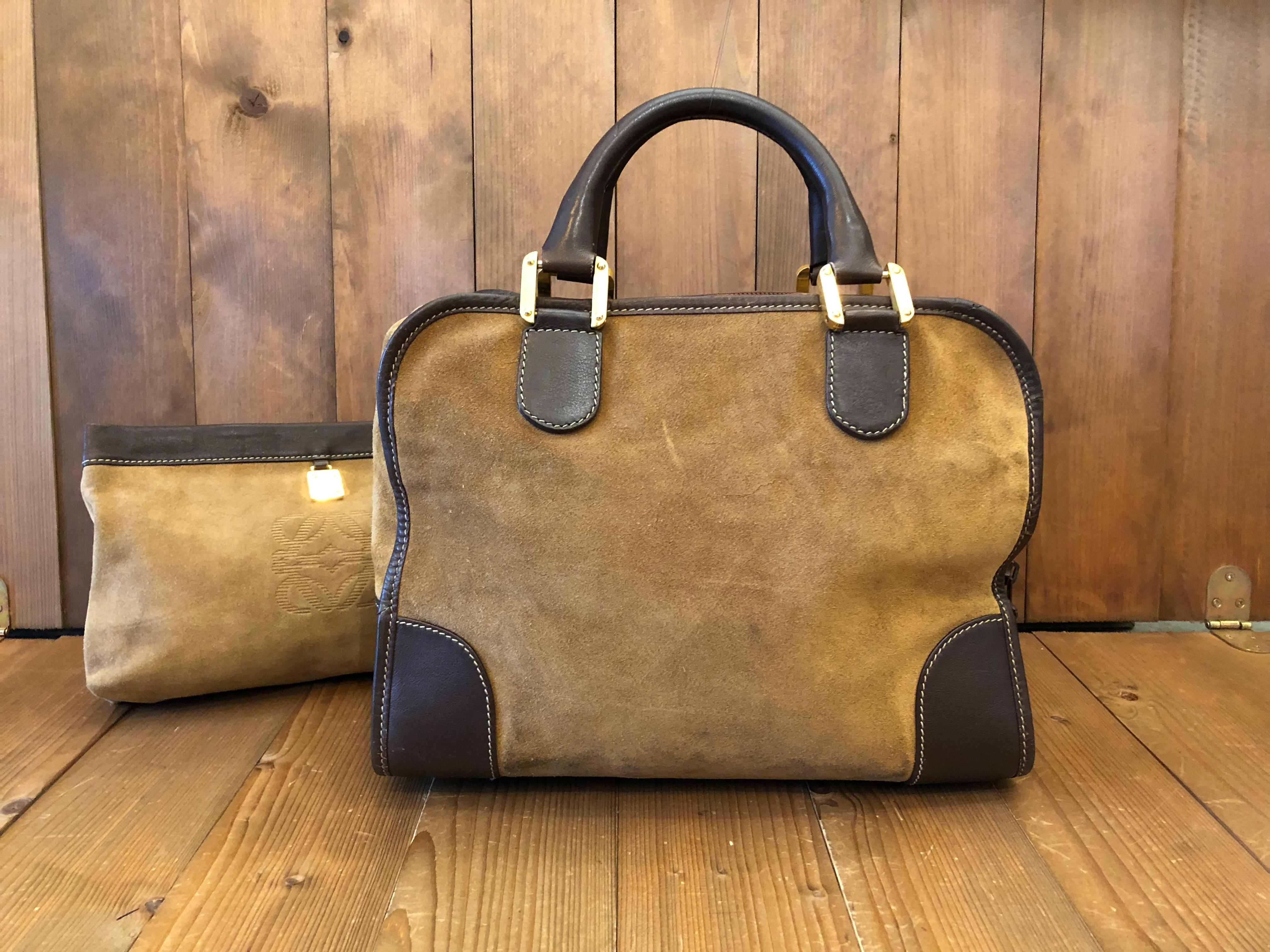 This vintage LOEWE Amazona boston bag is crafted of calfskin leather and suede in brown. Top zipper closure opens to a brown leather interior featuring a zippered pocket. Measures approximately 12.5 x 9 x 6 inches Handle drop 4 inches. Comes with