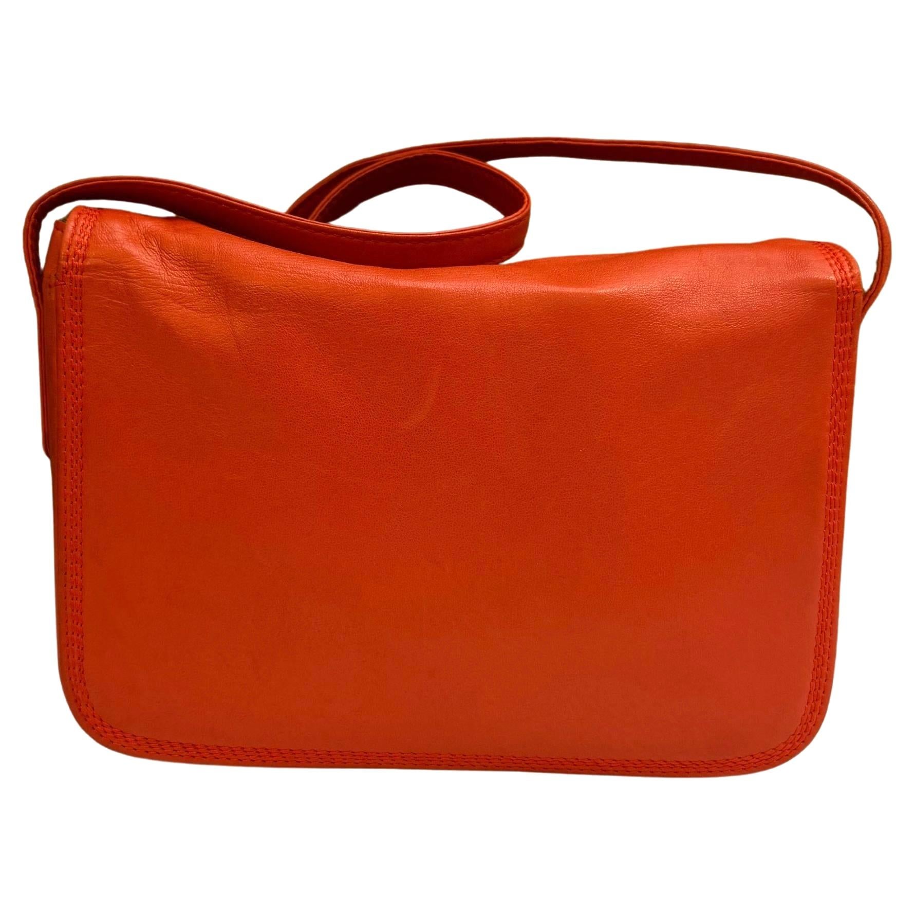 This vintage LOEWE Anagram crossbody bag is crafted of soft calfskin leather in orange with an adjustable shoulder strap featuring a wooden buckle. Top zipper closure opens to a coated interior which has been professionally cleaned with a zippered