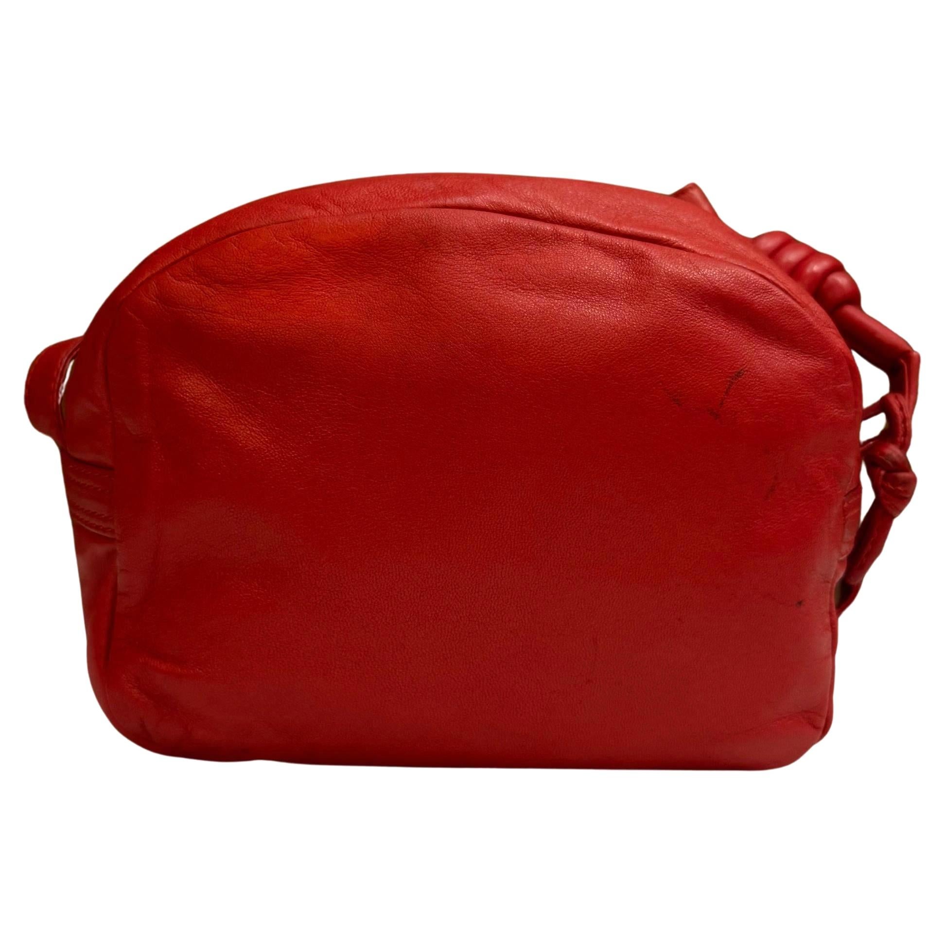 Este bolso bandolera vintage LOEWE Anagram está confeccionado en suave piel de becerro de color rojo. El cierre de cremallera superior se abre a un interior revestido que ha sido limpiado profesionalmente con un bolsillo con cremallera. Fabricado en