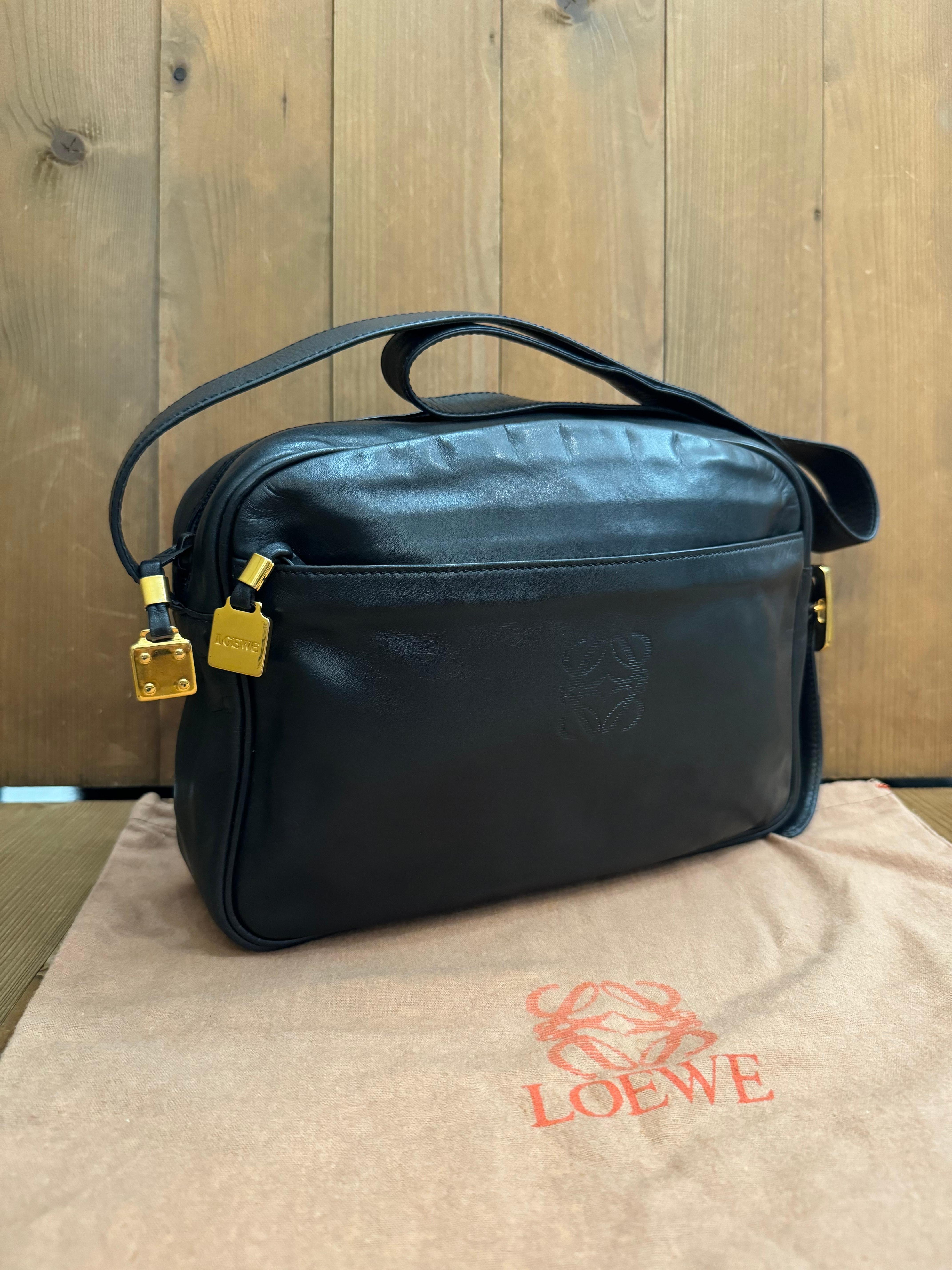 This vintage LOEWE Anagram camera bag is crafted of calfskin leather in black and gold toned hardware featuring an adjustable shoulder strap. Top zipper closure opens to a coated interior which has been professionally cleaned with stamps removed