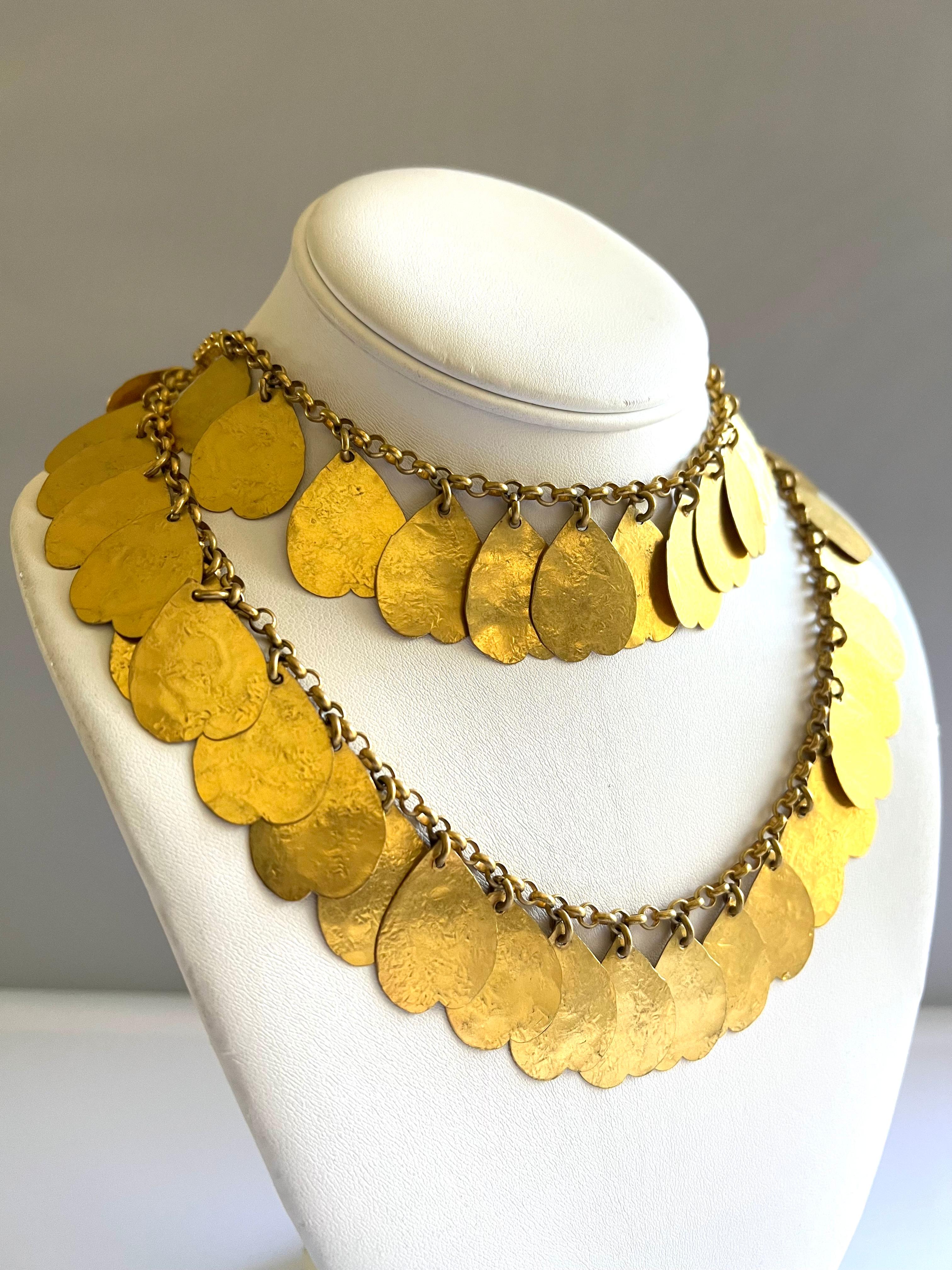 Vintage artisan hammered gilt metal chain charm necklace, by French designer Lola Prusac, circa 1960.

Lola Prusac was a Polish-born French fashion designer noted for her inventive and original way of dressing. She worked for Hermès in Paris between