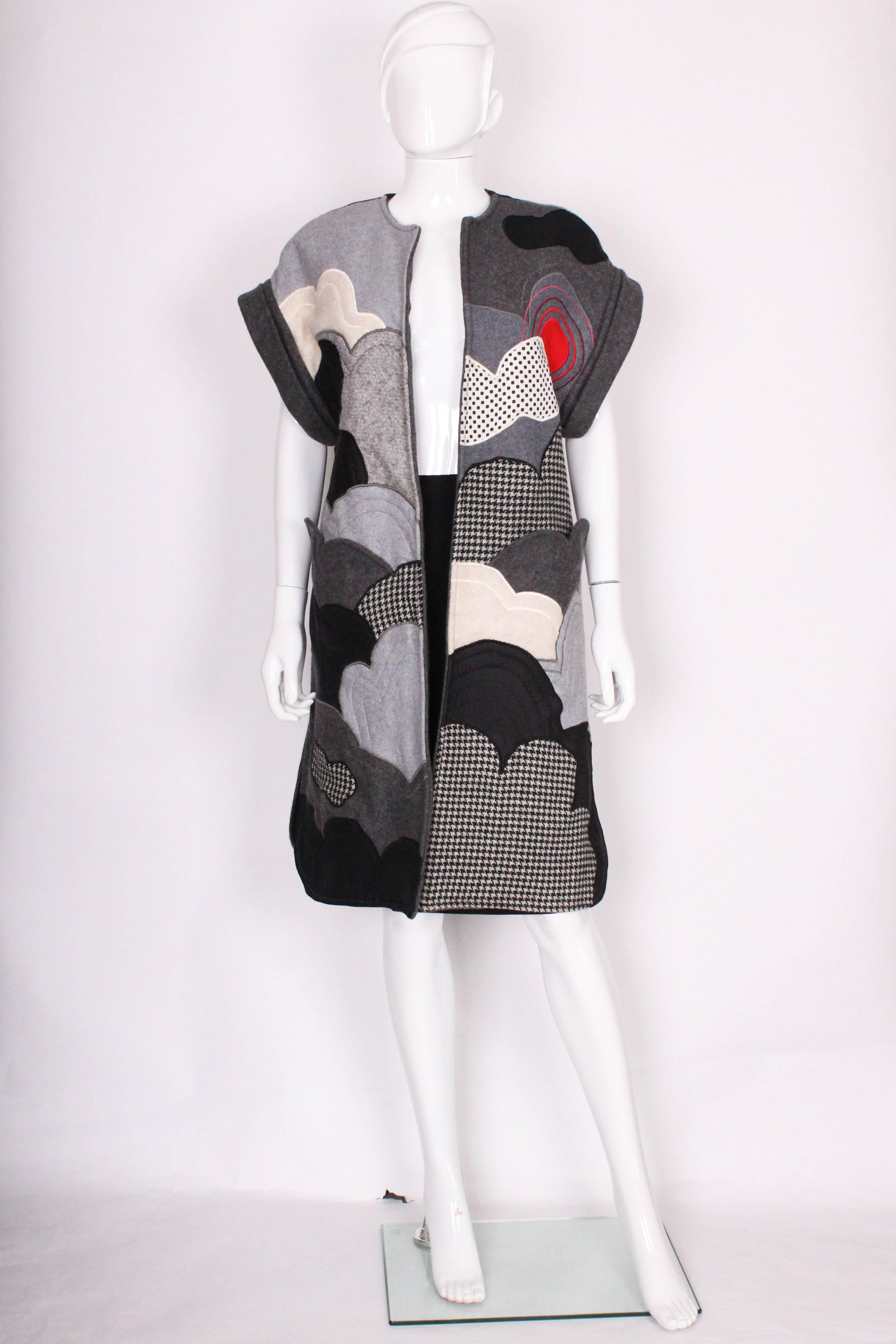 A great item for the coming months. This wool( fabric and knitted)  and cotton vest is by Tina,.and is wonderful for wearing over your work or play clothes. It is a fun design of various wool 'clouds' and has two pockets with scalloped edges. It is