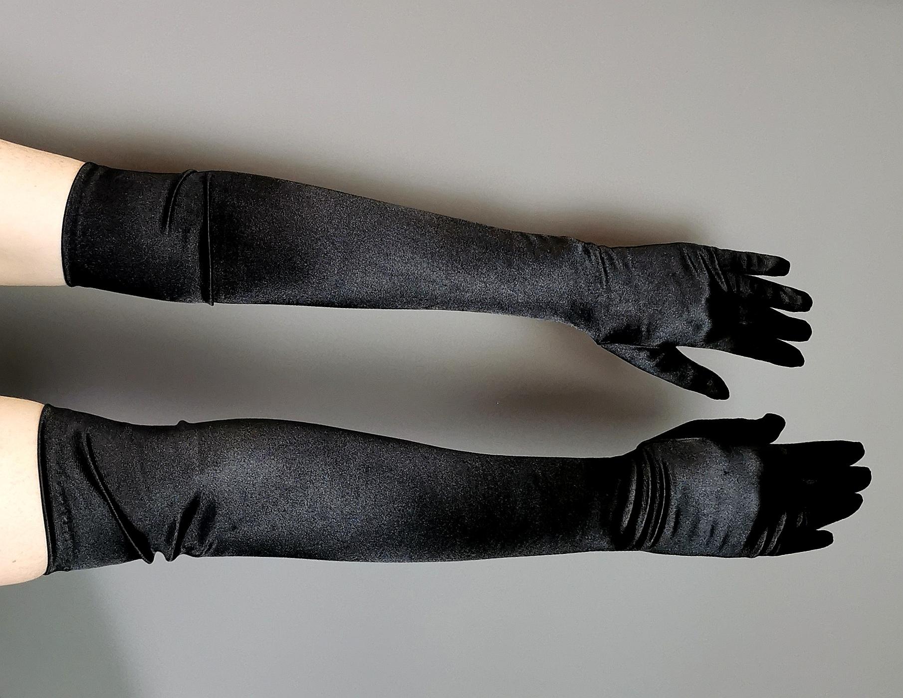 A gorgeous pair of vintage rich inky black long length gloves.

Also referred to as opera gloves this pair are very glam! A rich black with a slight sheen from the satin finish fabric, nylon with a touch of elastane.

They hug the arm and are sleek