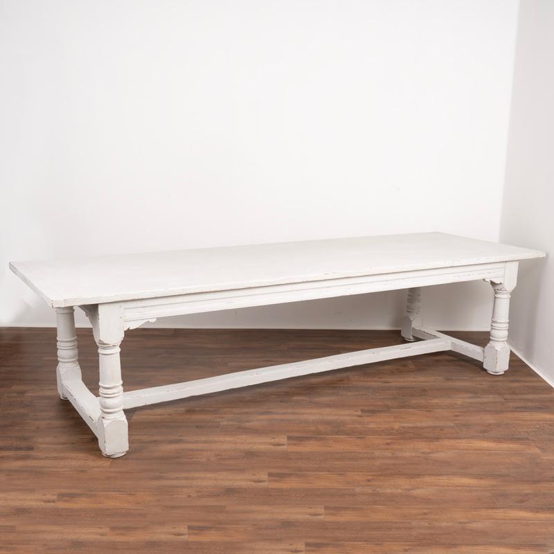 This long oak refectory table has been given a newer, professionally applied painted finish suited well for today's modern home. Please examine the close up photos to appreciate the layers and texture of white and gray paint, blended together for a