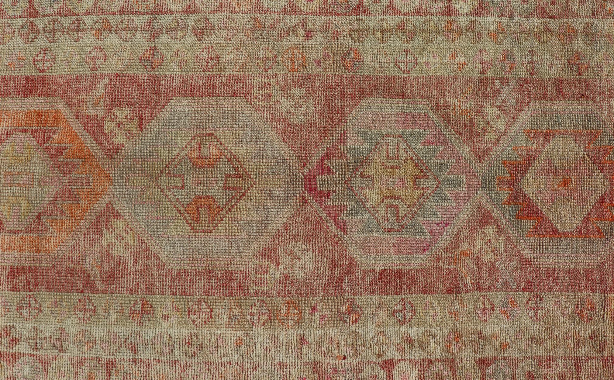 20th Century Vintage Long Turkish Oushak Runner with Tribal Medallions in Soft Red For Sale