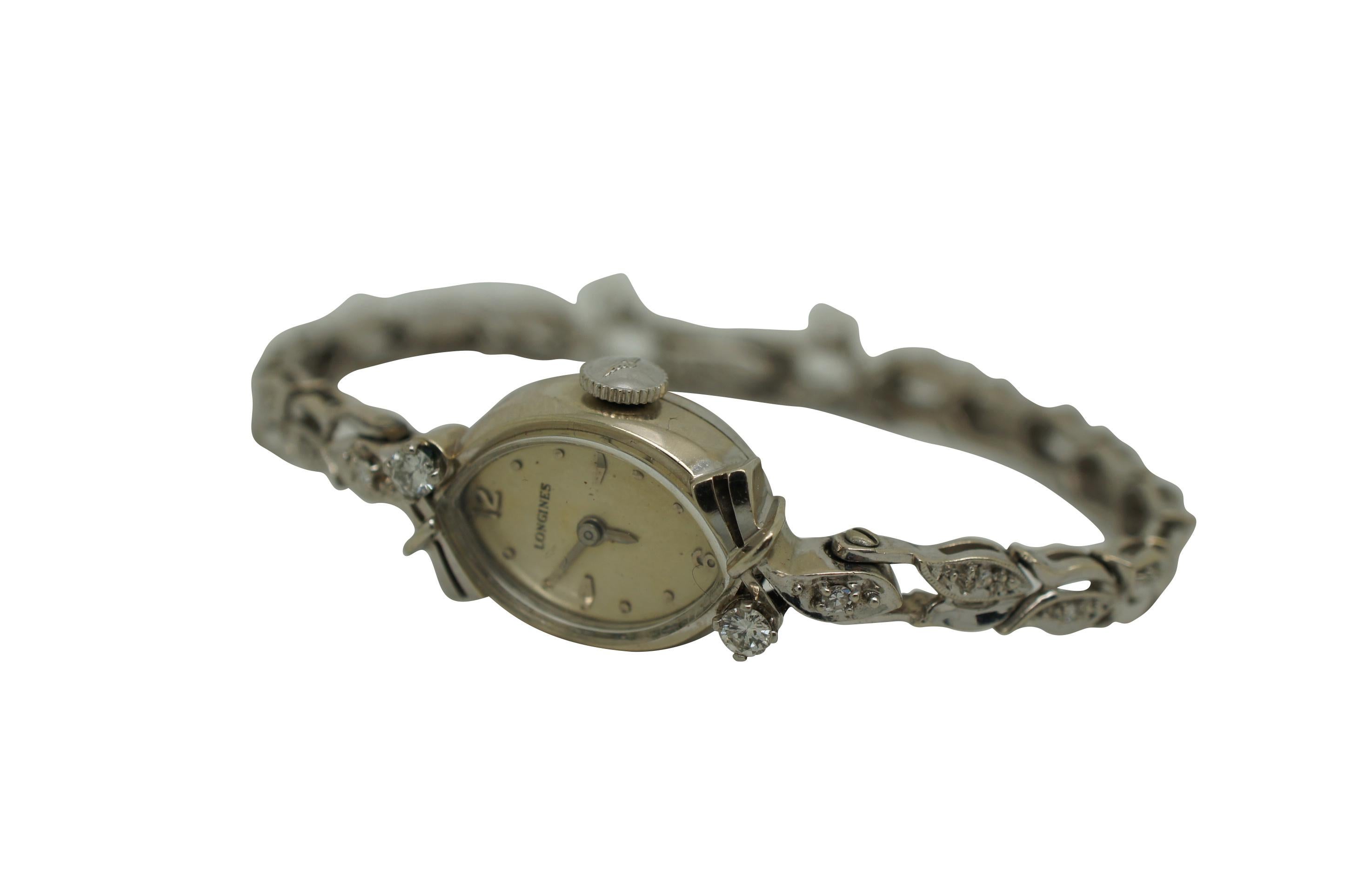 Schöne Vintage Longines Wittnauer Watch Co Inc. 14K Weißgold und Diamant Damen mechanische Armbanduhr. Das Band ähnelt einer Ranke aus Blättern oder Tulpen, die mit Diamanten besetzt ist. Mandelförmiges Gehäuse aus 14K Gold 592, Seriennummer 67309.