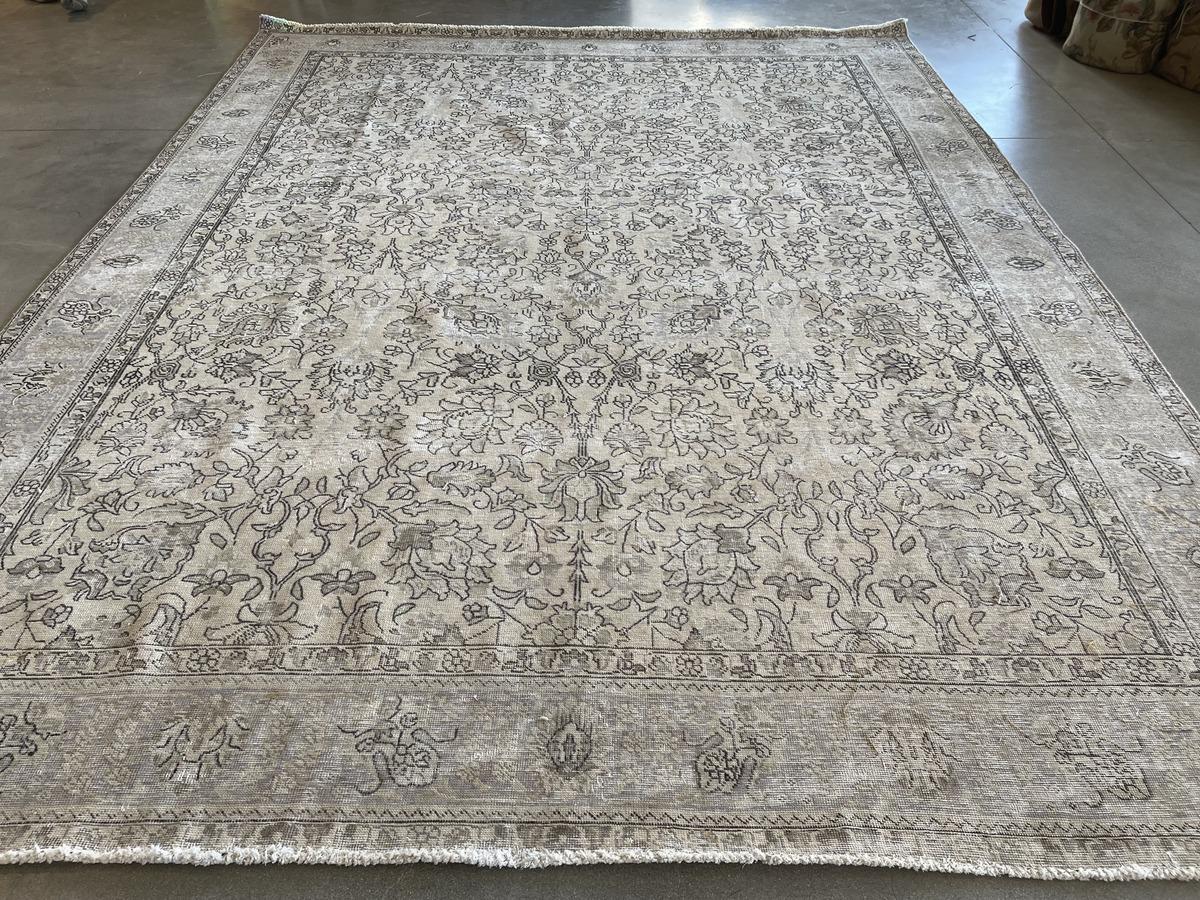 Traditional style meets modern sensibility in this contemporary area rug with floral center panel and wide frame. A meticulous shearing technique creates a one-of-a-kind distressed piece, removing pile but retaining the original design. Neutral