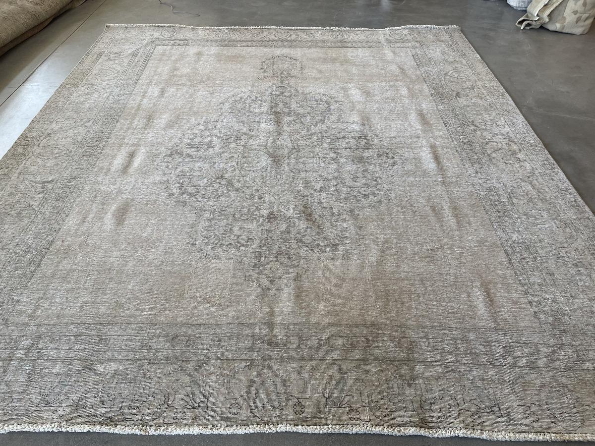 Traditional style and contemporary taste come together in this distinctive area rug with center medallion and wide stylized floral frame. A meticulous shearing process creates the captivating distressed quality, removing pile but retaining the