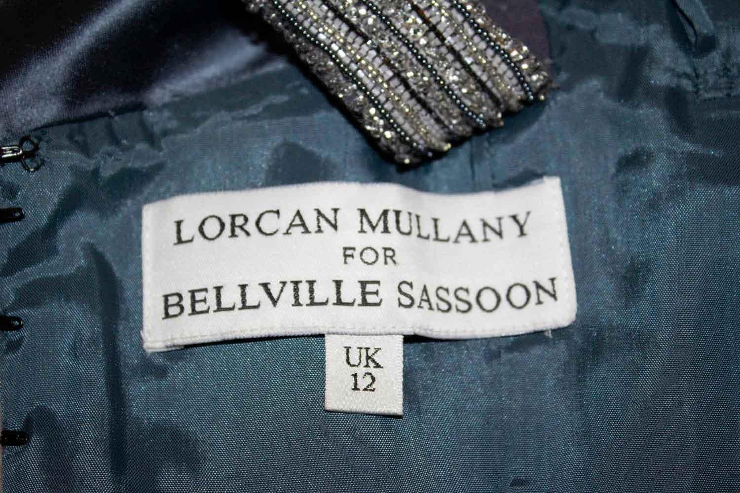A headturning vintage gown by Lorcan Mullany for Bellvill Sassoon. In a pretty steel grey silk, the dress has a rouched front with diamante detail, a built in bra/bodice  - that could be removed . There is detail on the straps and the dress is fully